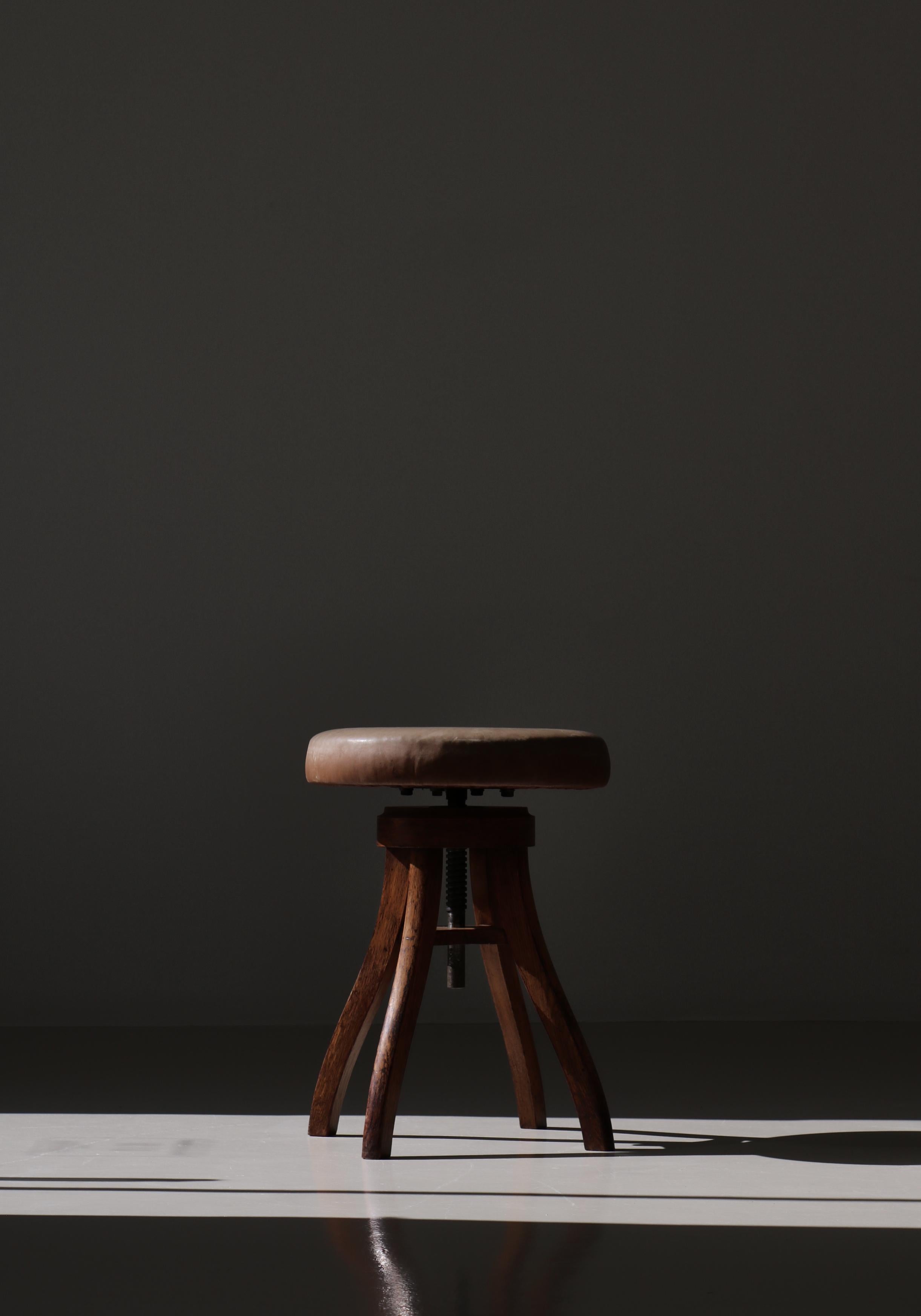 Großer und stabiler dänischer moderner Drehhocker, der Fritz Hansen, Dänemark, in den 1930er Jahren zugeschrieben wird. Der Hocker ist in sehr gutem Originalzustand. Das dicke und weiche Naturleder ist abgenutzt, hat aber eine wunderschöne
