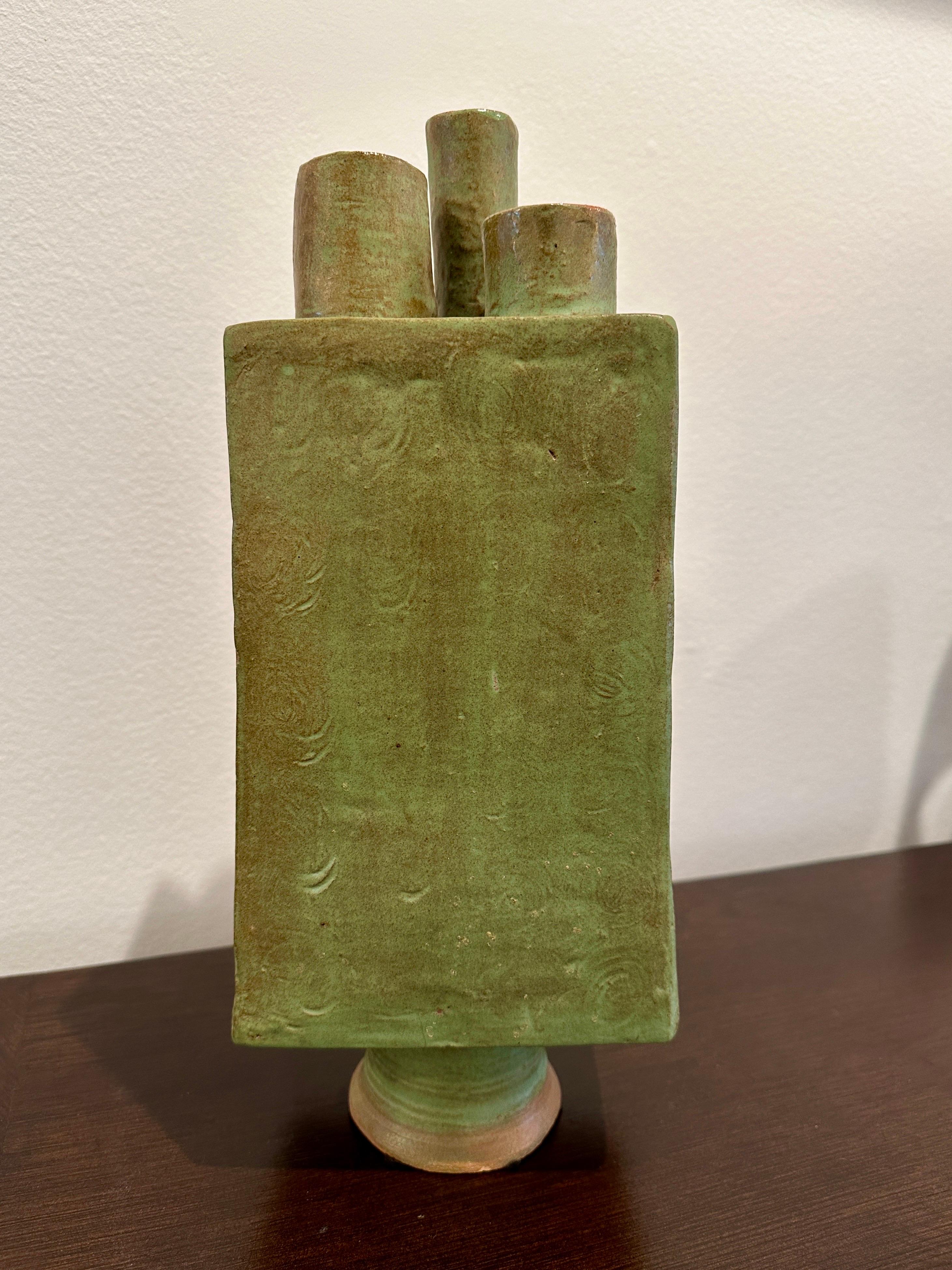 Questo vaso in terracotta smaltata verde con 3 stravaganti aperture per i fiori è molto pesante e scultoreo.  FIRMATO