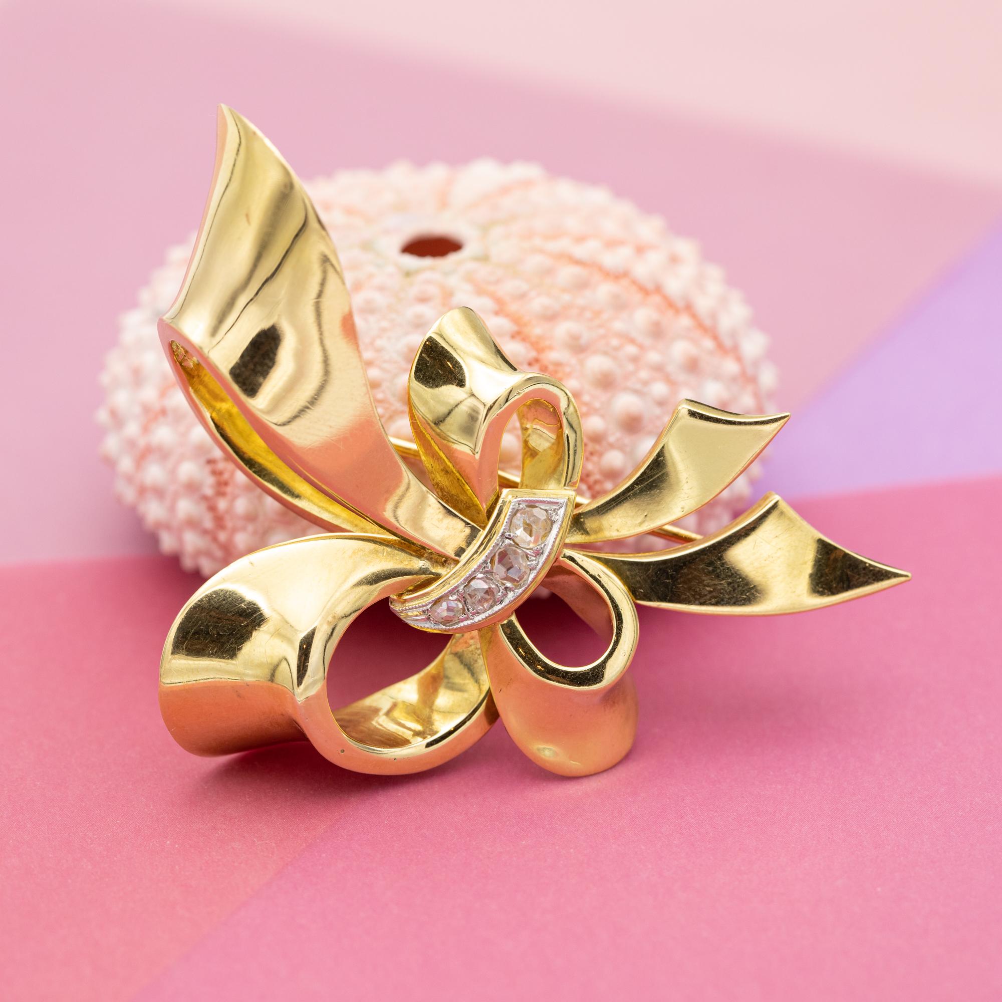 We are happy to introduce you to this lovely work of art from the mid-century, the 1940's, also known as the retro period. This collar brooch is crafted 18 K solid gold and depicts a lovely flowing ribbon forming a marvellous outsized bow. In the