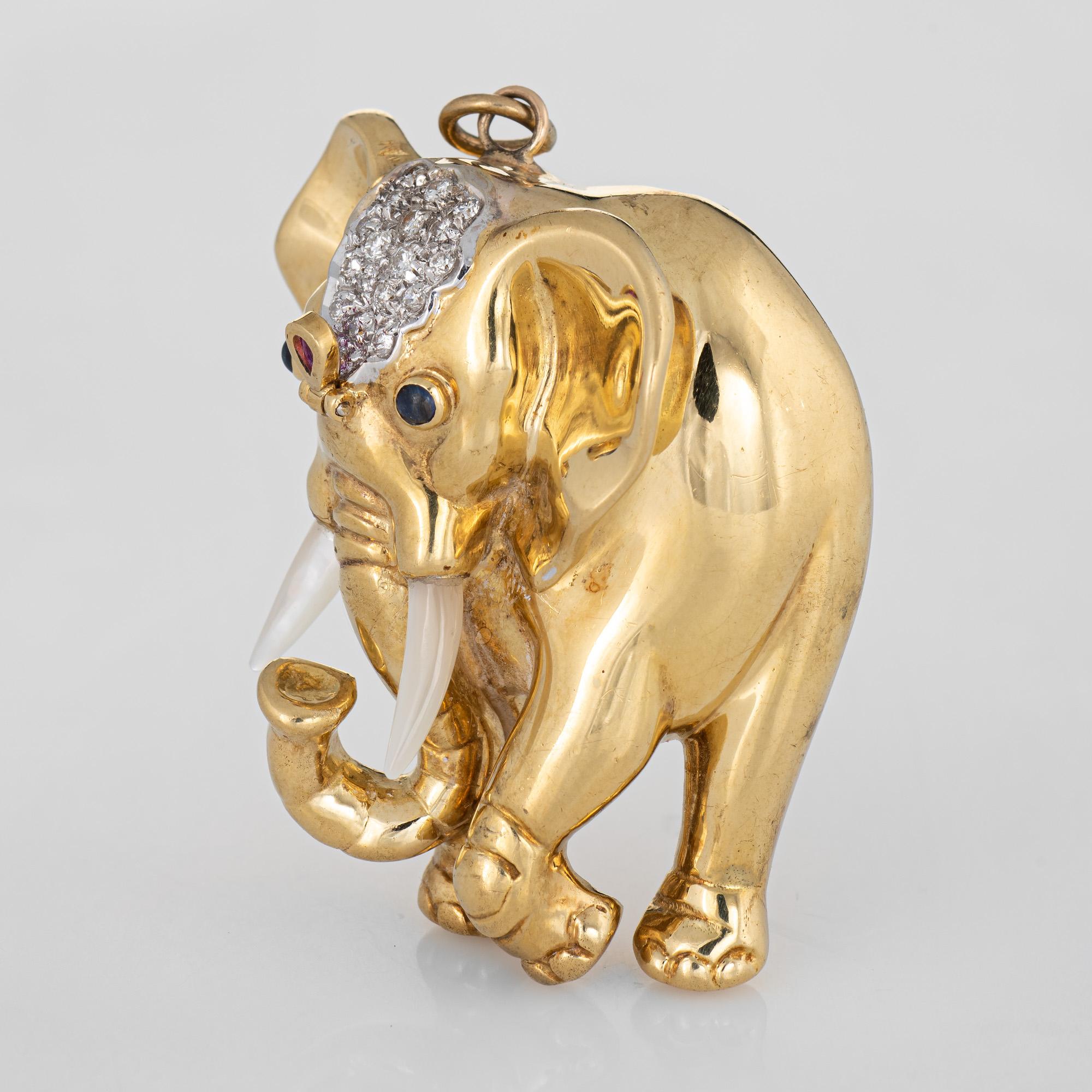 Finely detailed vintage Elephant pendant crafted in 18k yellow gold.  

Diamonds total an estimated 0.20 carats (estimated at G-H color and VS2-SI1 clarity). Cabochon cut sapphires are estimated at 0.03 carats each and one pear cut ruby is estimated