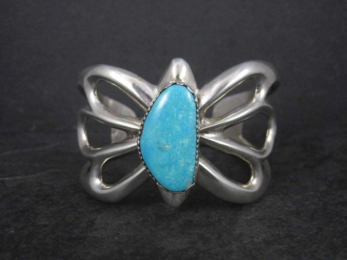 This gorgeous Southwestern sandcast cuff bracelet is sterling silver with a 13x25mm genuine turquoise stone.

Measurements: 1 9/16 inches at its widest - Inner circumference of 6 1/4 inches, including the 1 1/8 inch gap.
Weight: 62.5 grams

Marks: