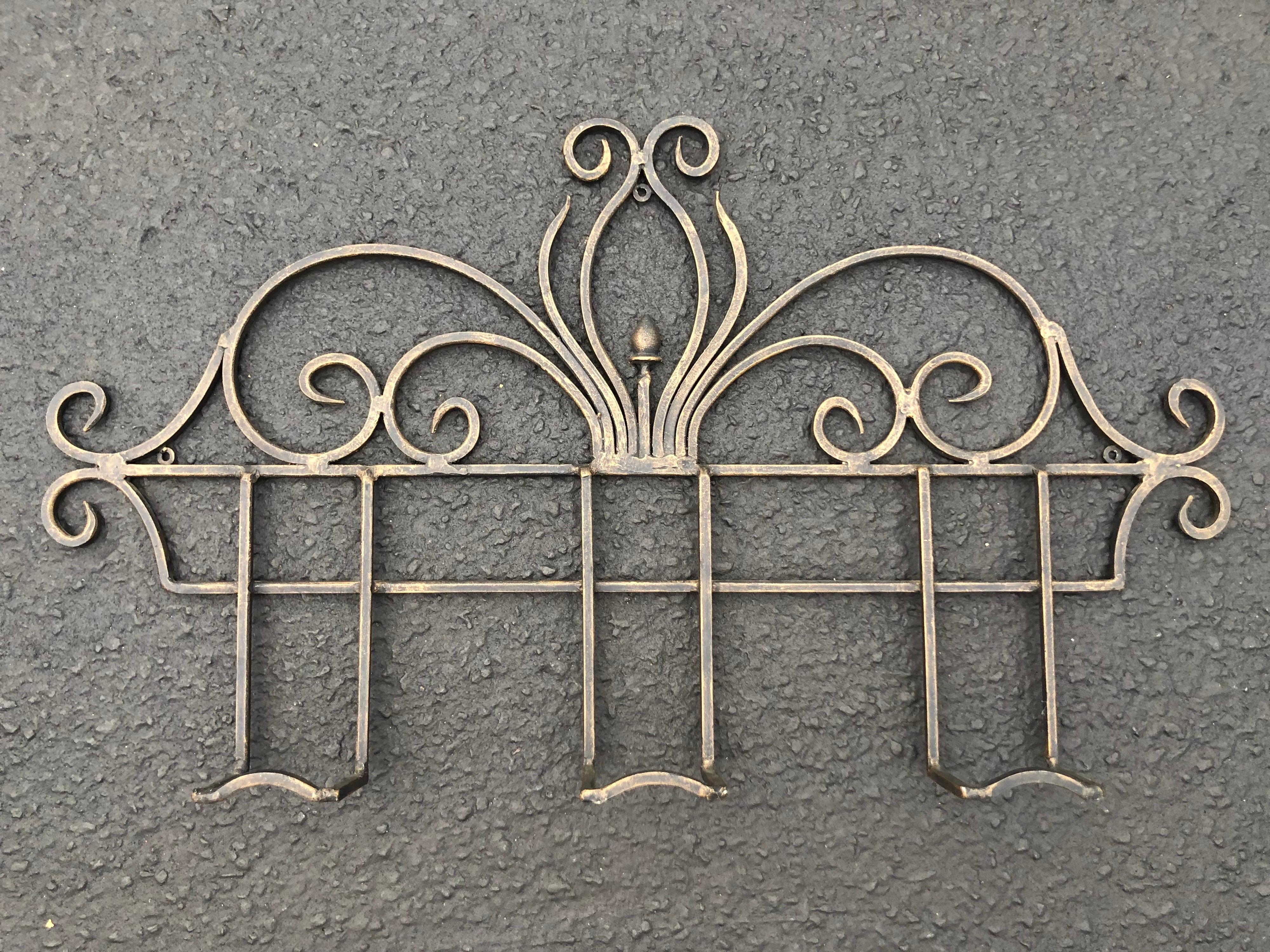 Decorative iron wall coat rack. Simple lines and design make up this silver iron rack. Perfect for an entry way or use in a bathrooom to hang towels or robes . Also sturdy enough to use outdoor as well. Art Deco style.
       
