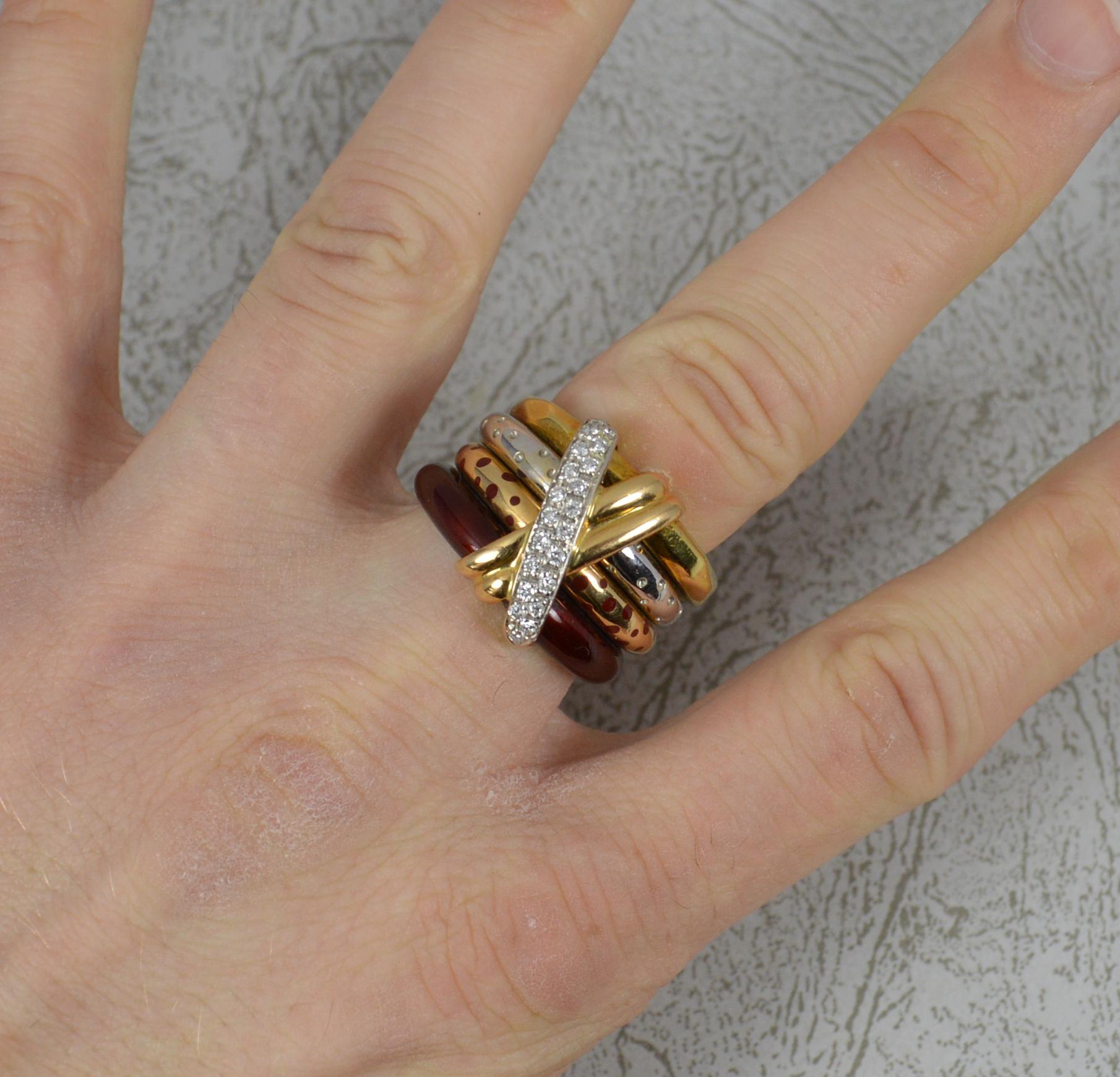 A stunning La Nouvelle Bague designer ring.
Solid 18 carat gold four band stack ring.
A cross over kiss design front, half yellow gold, half white encrusted with diamonds.
Four bands to include; textured yellow gold, white gold with small dots,