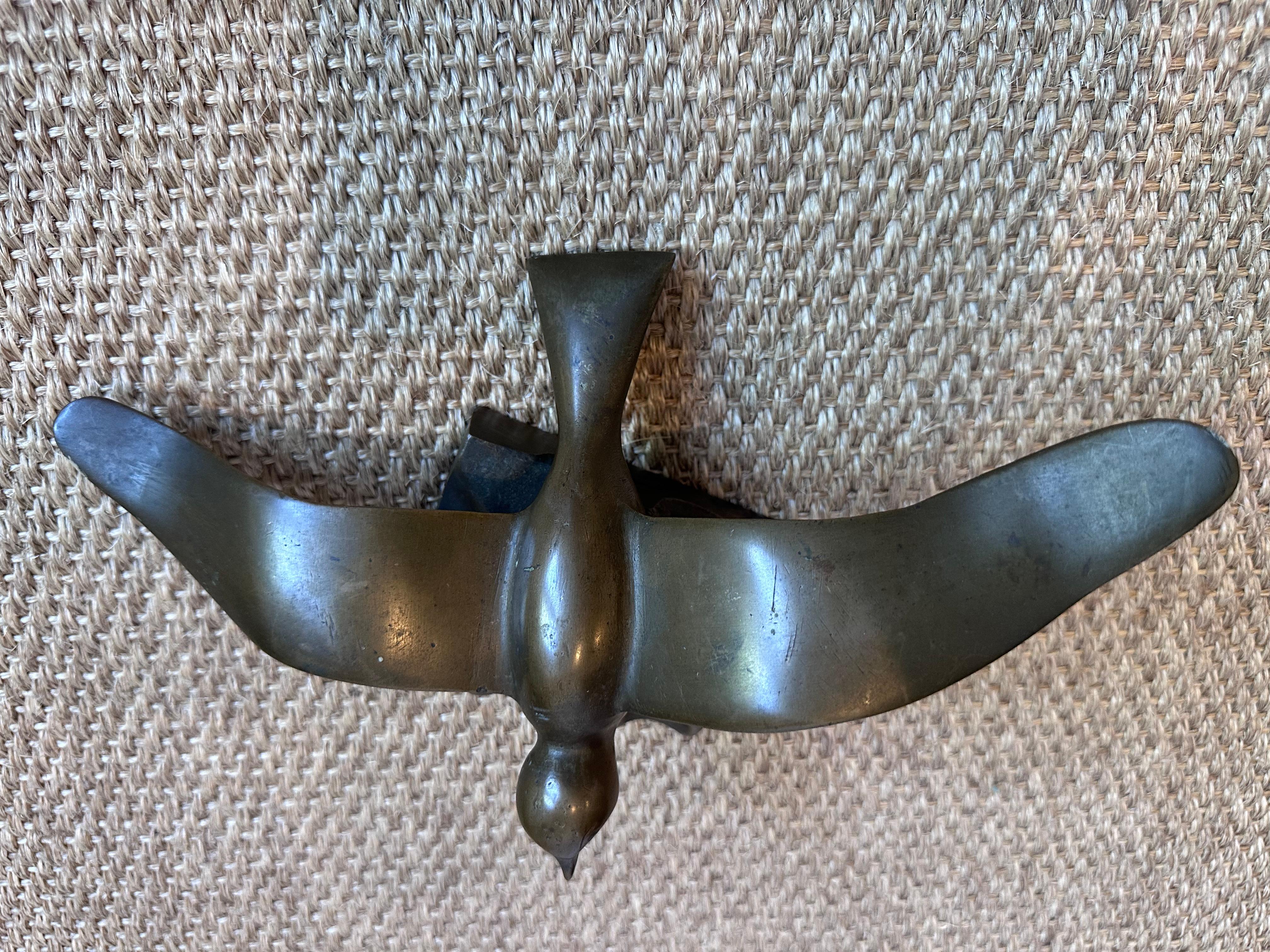 Cette sculpture représente un oiseau en plein vol, aux ailes gracieuses et enveloppantes et au corps fuselé. Les ailes de l'oiseau sont élégamment déployées, suggérant le mouvement et la fluidité, tandis que le corps est compact et légèrement