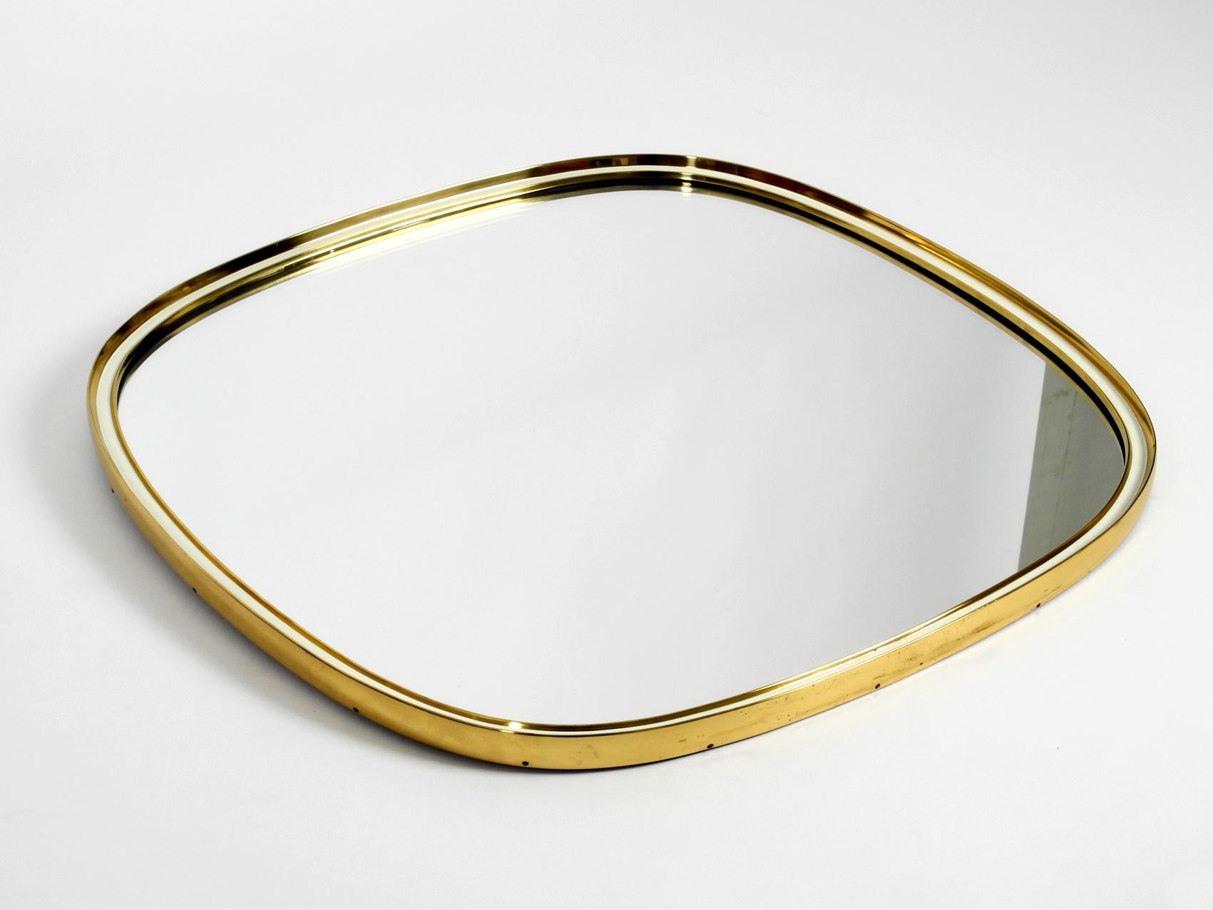 Beautiful heavy Mid-Century Modern wall mirror with heavy brass frame.
Manufacturer is Vereinigte Werkstätten. Made in Germany. Great 1950s minimalistic design.
Very high quality and solid. Weight approx. 8 kg.
Very good condition without damages