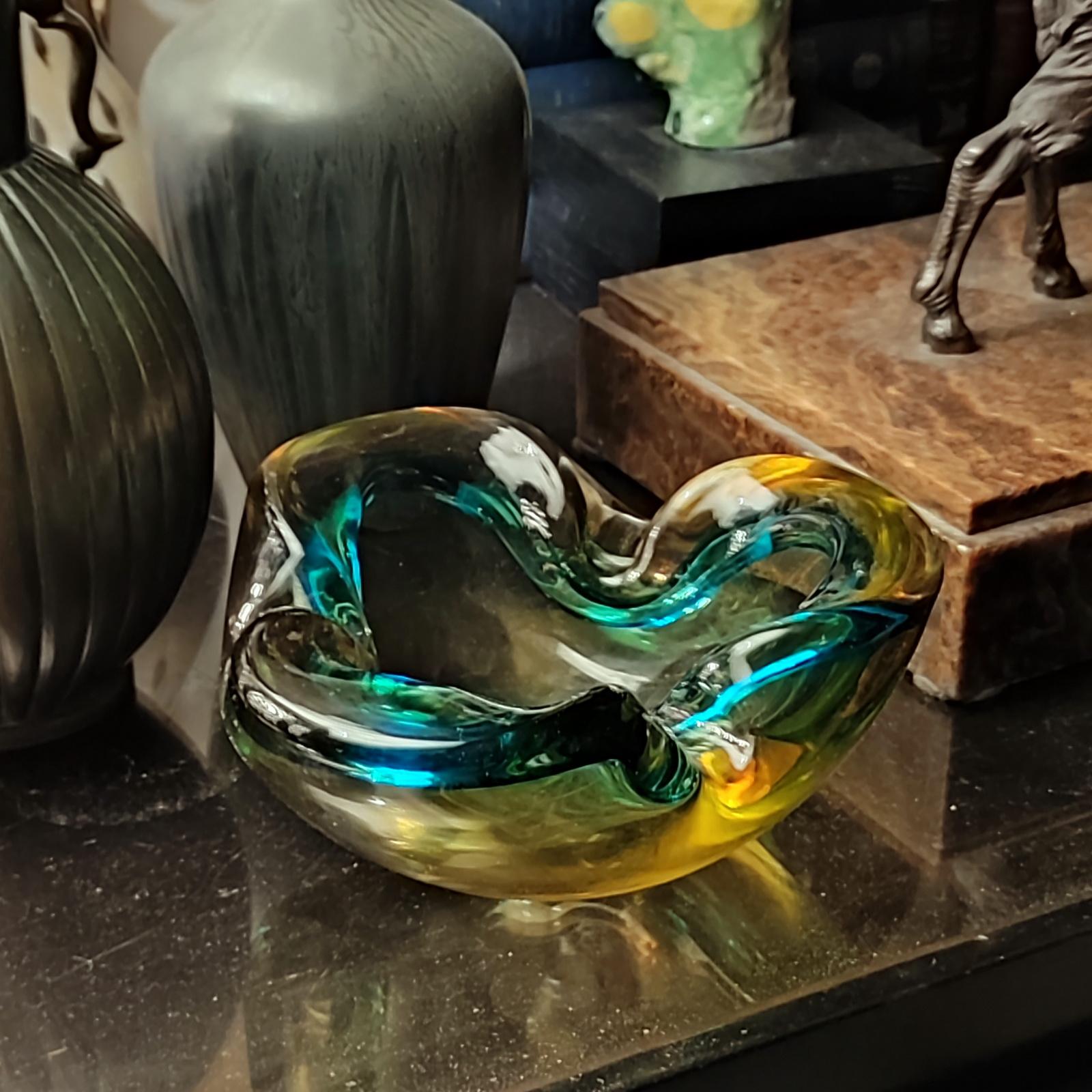 Flavio Poli pour Seguso, 1970
Cendrier en verre de Murano en forme de coquille, réalisé en verre ambré et turquoise enchâssé dans du cristal, technique sommerso. Objet hautement décoratif, magnifique pour être utilisé non seulement comme cendrier,