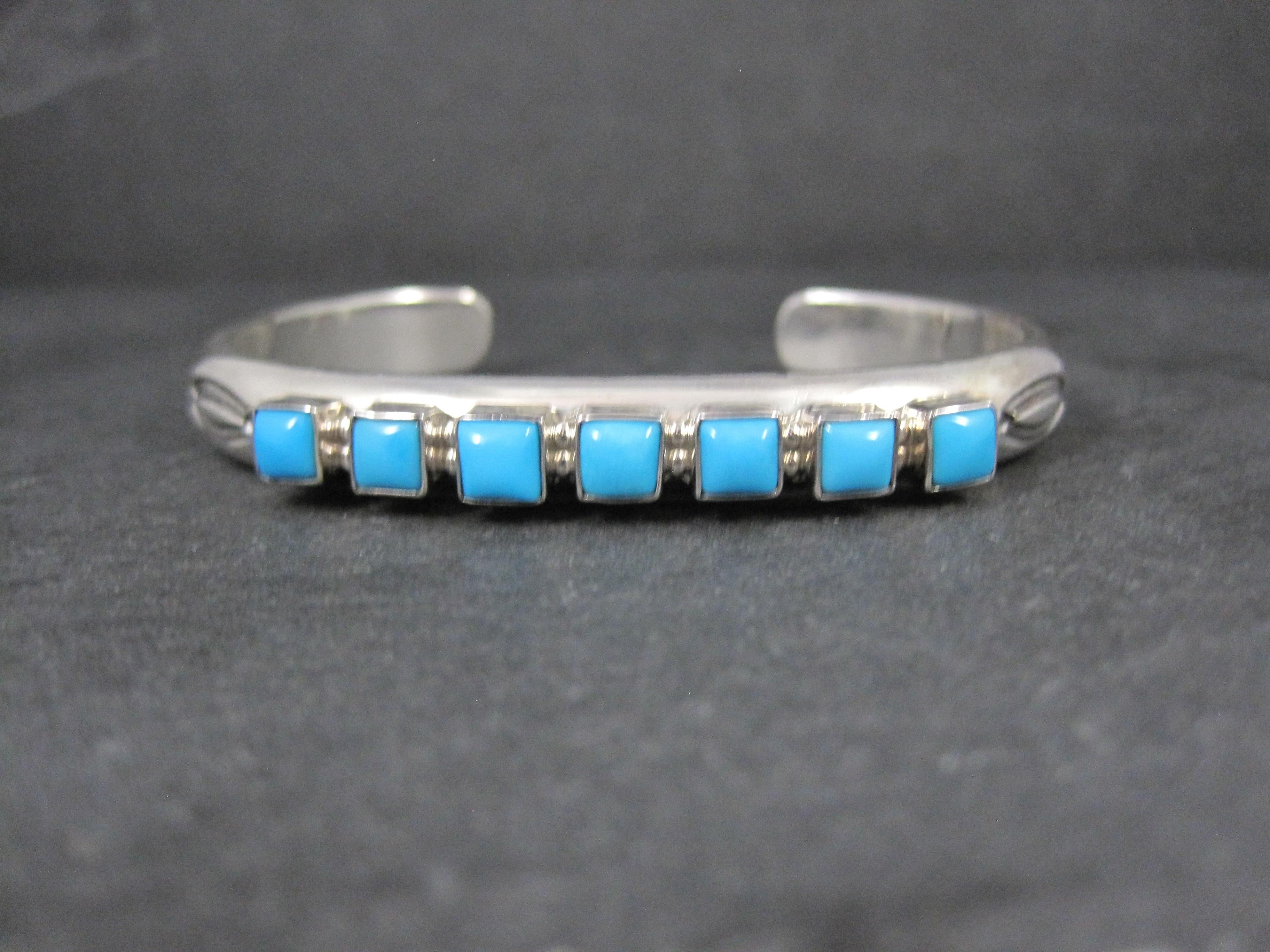 This gorgeous, heavy Native American cuff bracelet is sterling silver with 7 square cut turquoise from the Kingman mine.
It is the creation of Navajo silversmith Thomas Yazzie.
It measures 5/16 of an inch wide. It has an inner circumference of 6.5