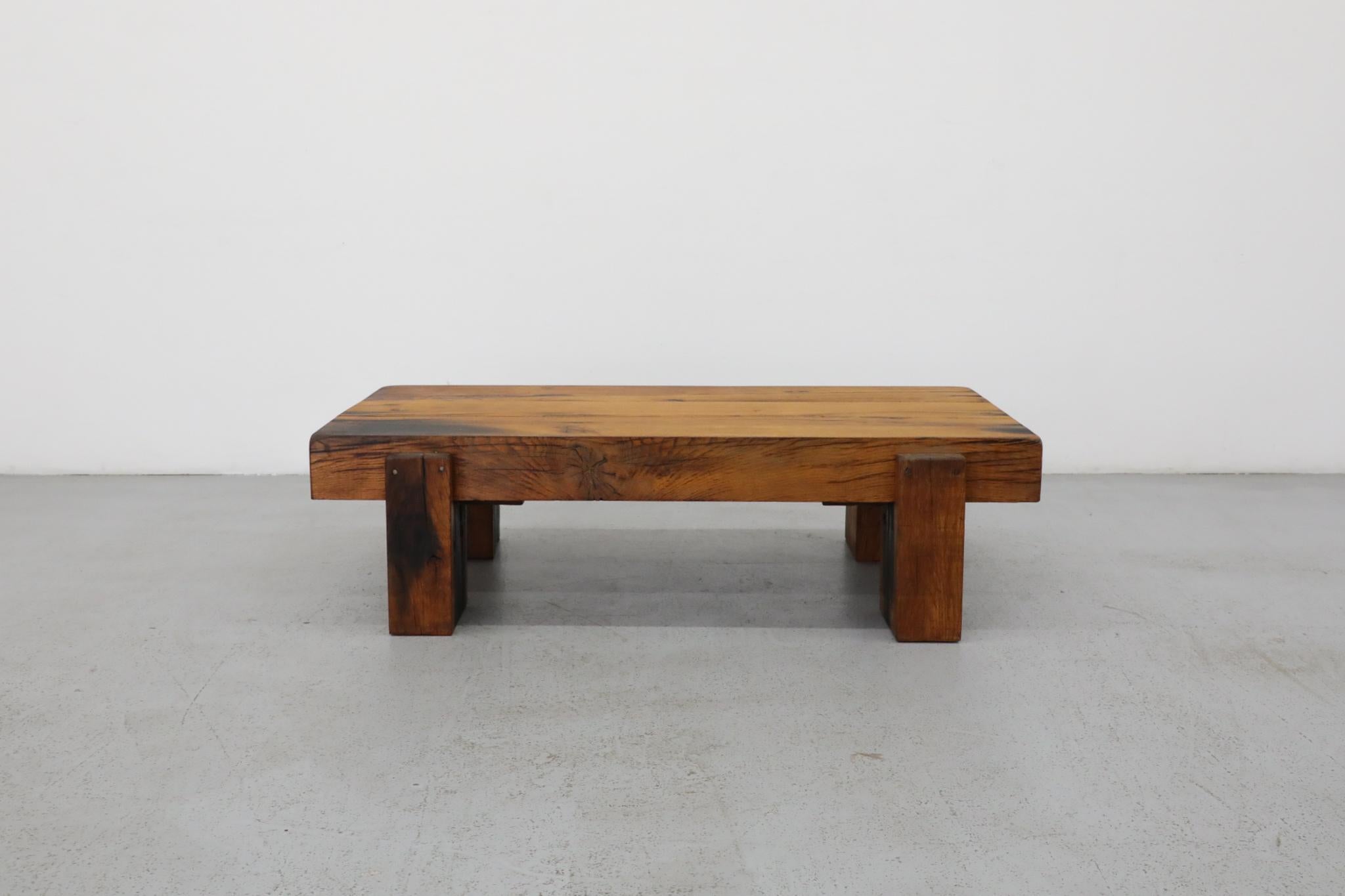 Attractive Pierre Chapo style heavy oak Brutalist coffee table. A handsome solid wood coffee table with visible wear and patina that highlights its well worn style. A 4.75” solid wood top on four large wood post legs. In original condition with wear