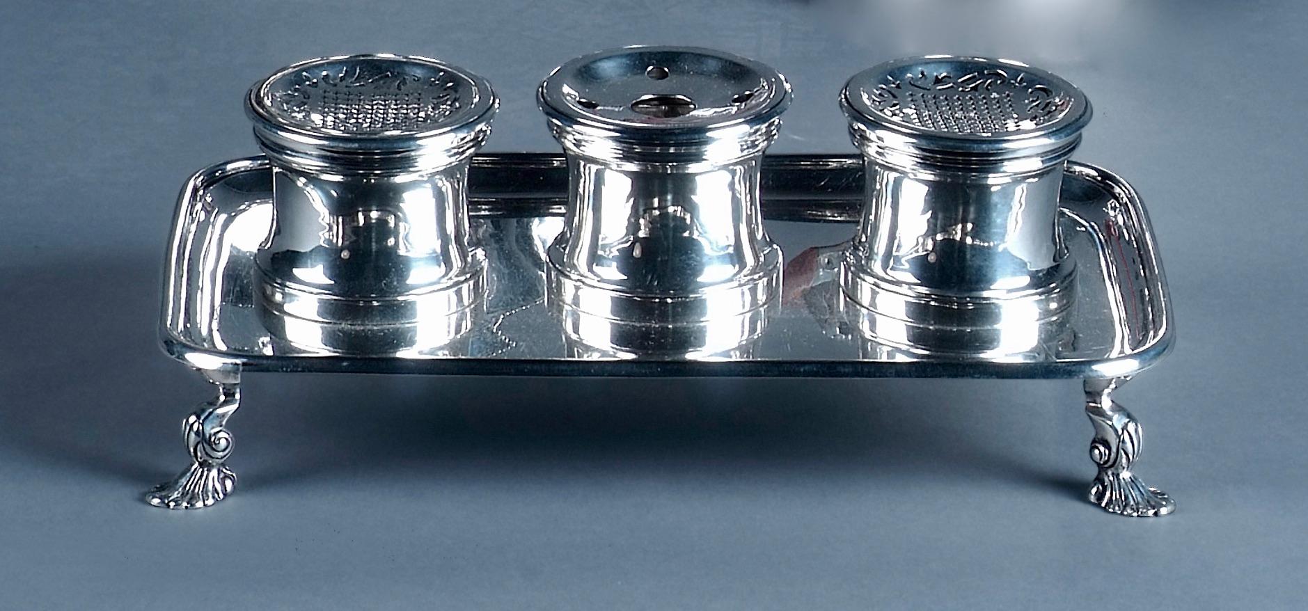 George I style plain silver inkstand on four shell and scroll feet, fitted with three capstan wells, retailed by Lambert & Harman, 177 New Bond Street, London.
