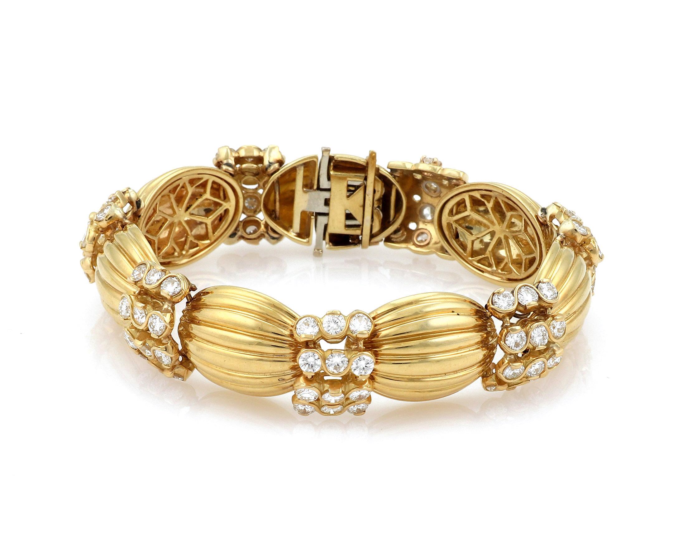 This stunning bracelet is crafted from solid 18k yellow gold with a polished finish and has 7 dome shape fluted links with 12 round cut diamonds mounted in a swirl design frame set between each fluted dome link. The total weight of the diamonds are