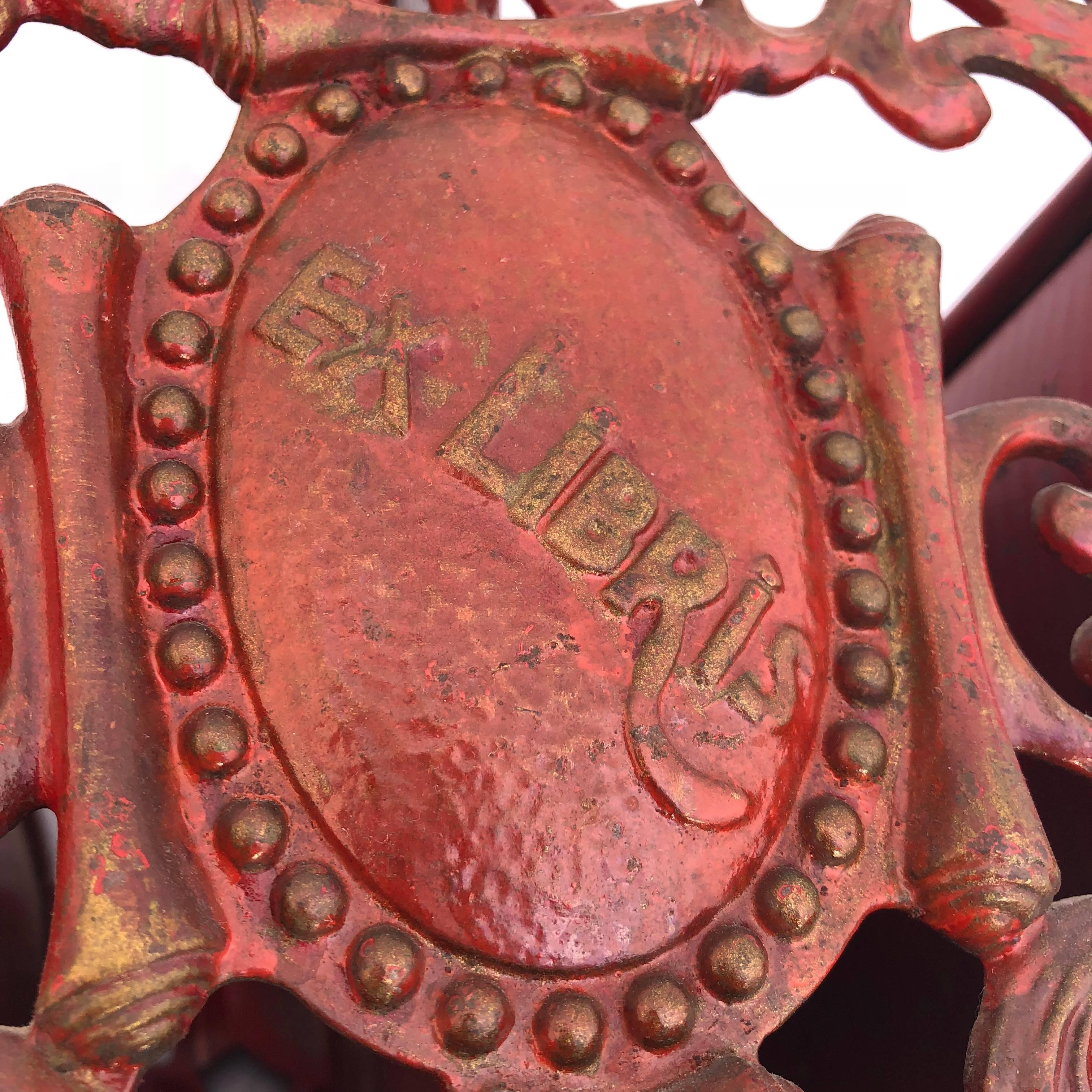 Heavy solid red painted wrought iron magazine rack.