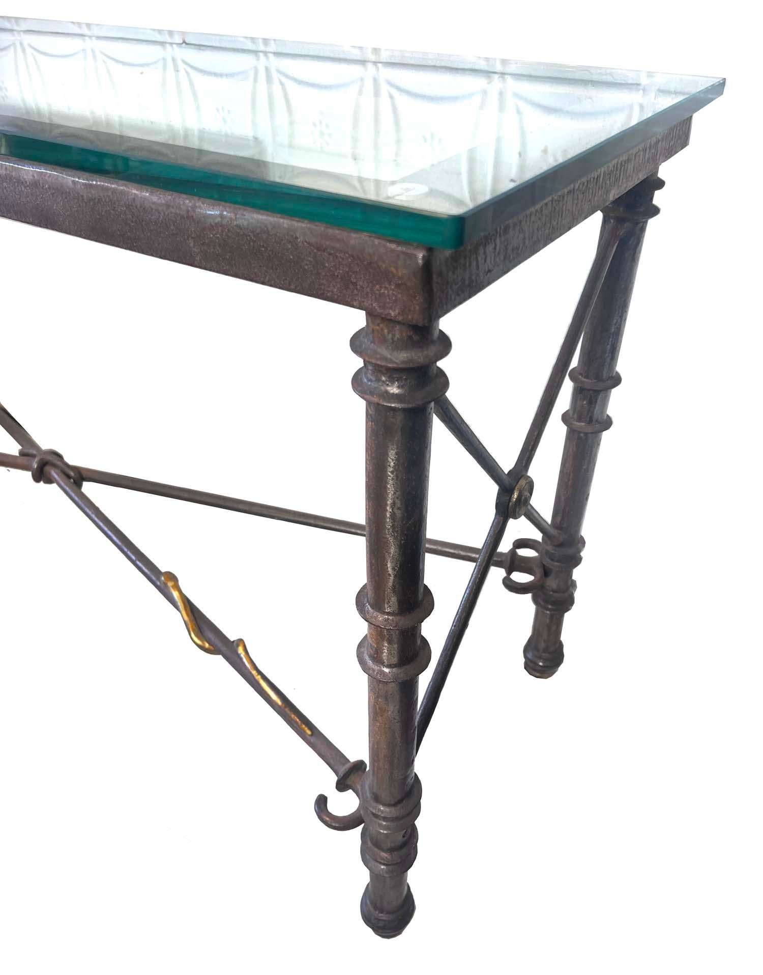 This is an amazing console constructed of pounded and bent steel and brass. The heavy steel is hand molded to form this unique console trimmed with bulls eye brass and a small brass snake working its way across the bottom stretcher. The top is a