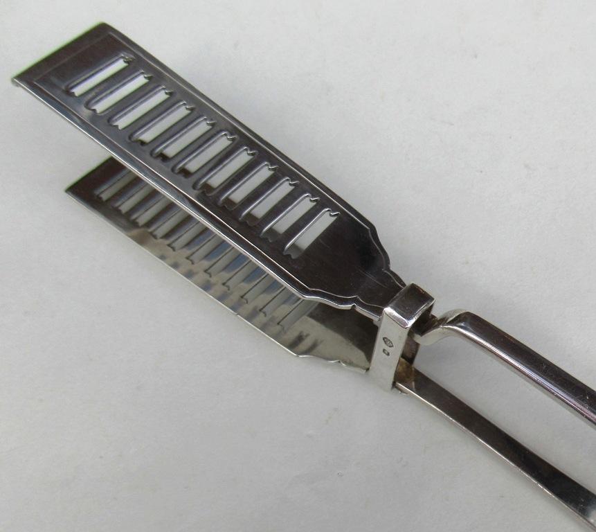 Superb Heavy Gauge Sterling Silver Asparagus Serving Tongs of Traditional Form, with unusual decorative ladder pattern blades.

Mark of WS&L for William Hutton & Sons. West Street, Sheffield.

Sheffield Hallmark for 1923.

Condition: Good