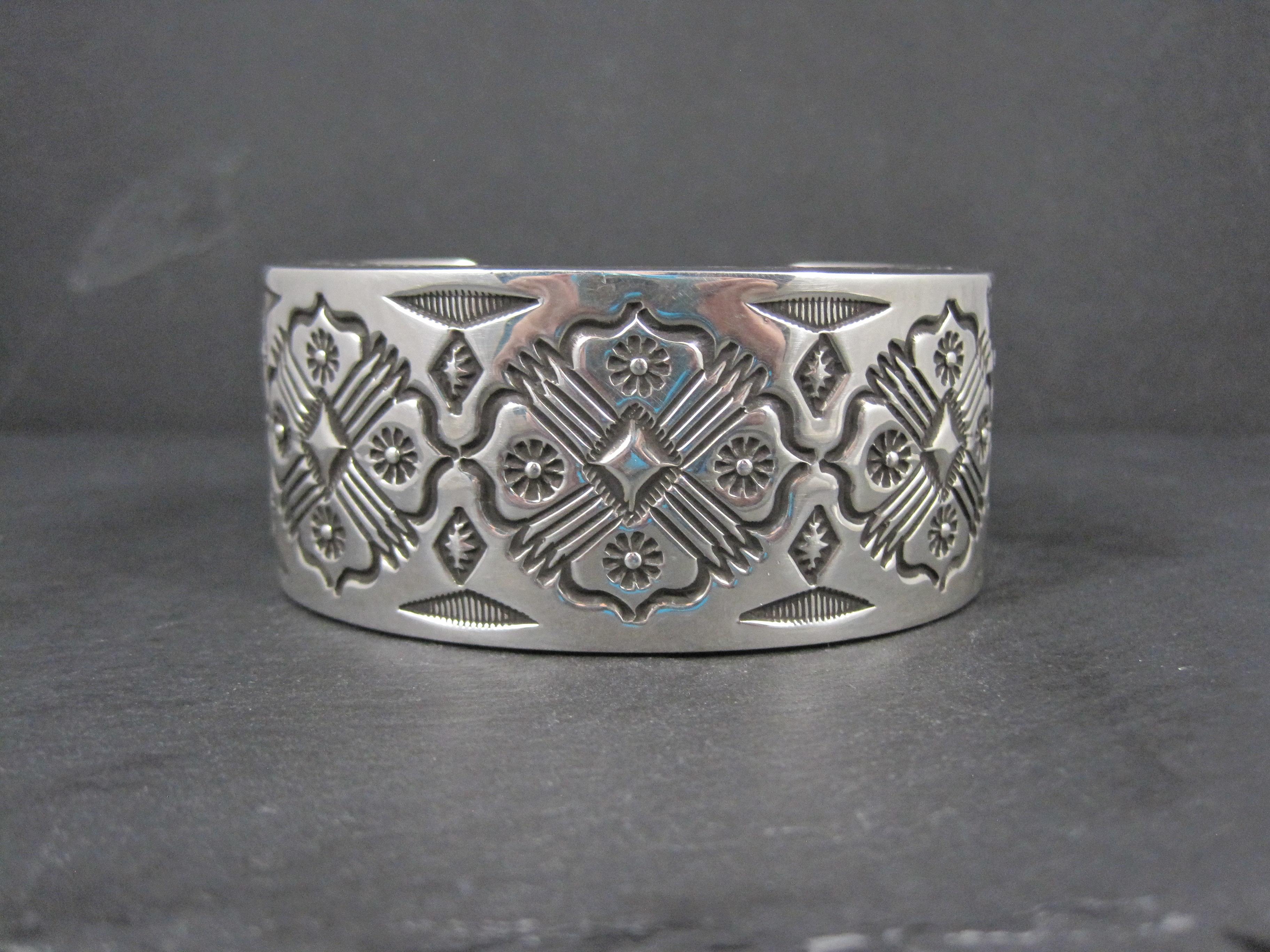 This gorgeous, show-stopping cuff bracelet is sterling silver. It features designs on both the inside and outside of the cuff.
It is the creation of talented Navajo silversmith Leander Tahe.
This cuff bracelet measures 1 3/8 inches wide. It has an