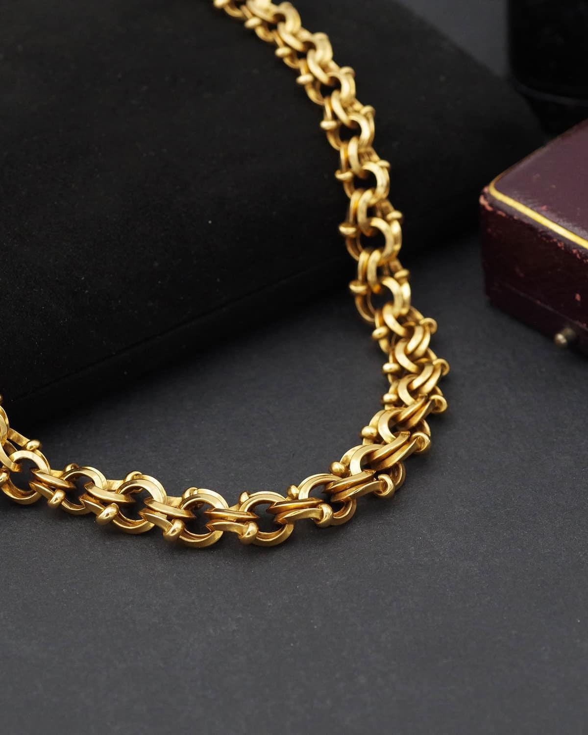 Important collier à double maille en or jaune 18 carats. Ce collier se compose d'un maillon fantaisie avec des anneaux à double emboîtement ornés de boules en or. Les liens sont en or massif. Le maillon est disposé en goutte d'eau, d'une largeur
