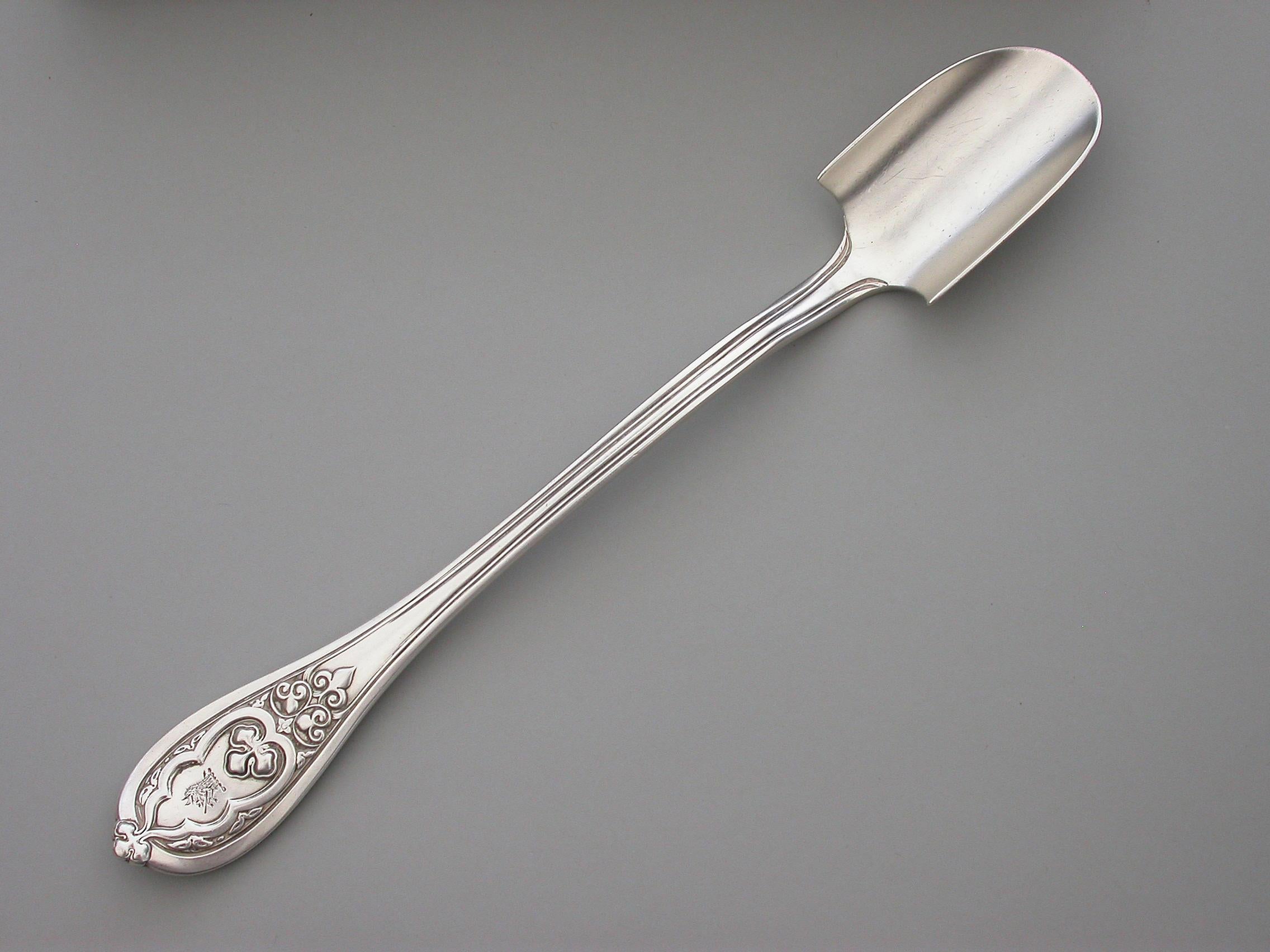 A good quality and very heavy gauge Victorian silver Stilton Cheese Scoop, in 'New Gothic' pattern. The terminal engraved with a crest.

By George Adams, London 1868.

122.00 grams (3.92 troy ounces).