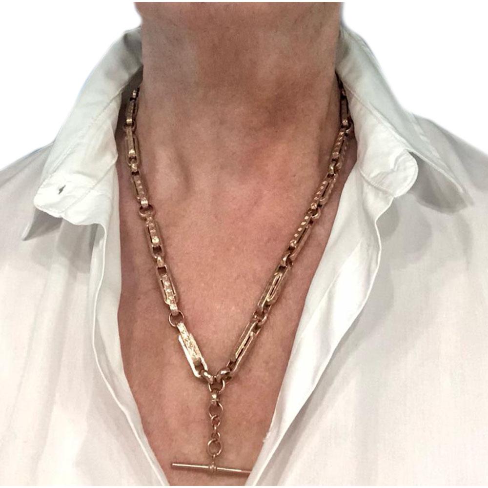 A super heavy 9 karat rose gold Albert chain measuring 20” (510mm) long with an attached T bar. Each long fetter link is embossed with a chevron pattern, interspaced with faceted round links. And fastens with two claw fasteners. Originally intended
