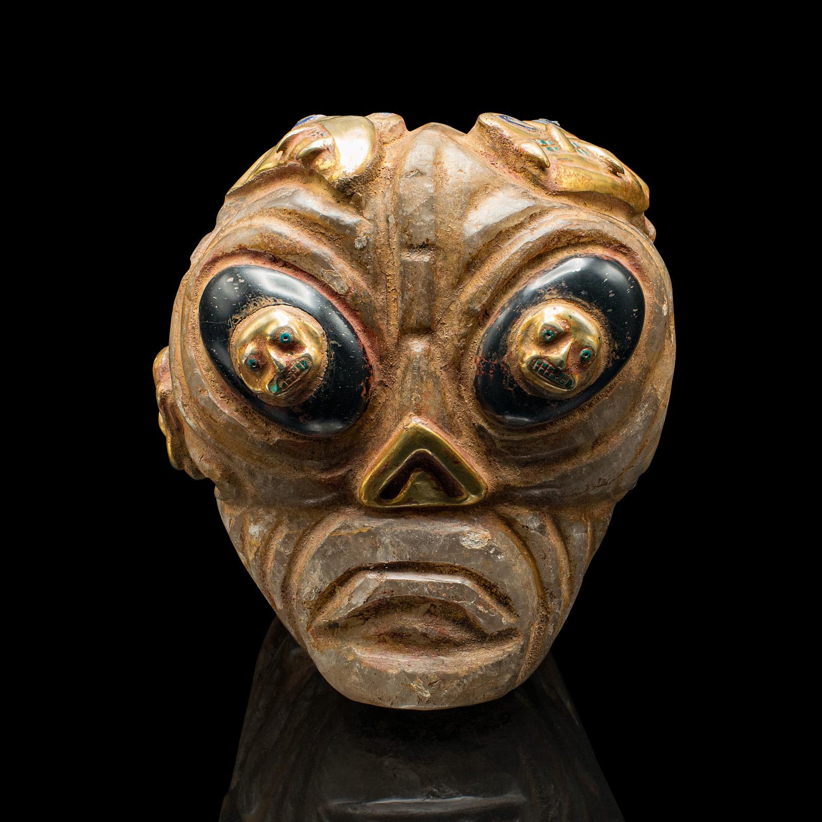 
This is a heavy vintage deity head. A South American, carved crystal and gilt metal decorative artefact, dating to the mid 20th century, circa 1950

Highly distinctive and fascinatingly heavy skull in the Inca or Pre-Columbian manner
Displays a