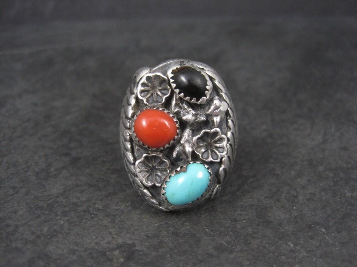 This gorgeous vintage ring is sterling silver with tigers eye, turquoise and coral stones.
It is the creation of Navajo silversmith Frances Jones.

The face of this ring measures 1 3/16 inches north to south.
Size: 9
Weight: 37 grams

Marks: