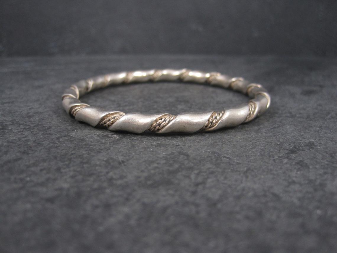 This gorgeous vintage, Southwestern twisted bangle bracelet is sterling silver.

Measurements: 6mm thick, inner circumference 7 3/4 inches, inner diameter 2 1/2 inches
Weight: 45.5 grams

Marks: None - acid tested

Condition: Excellent
