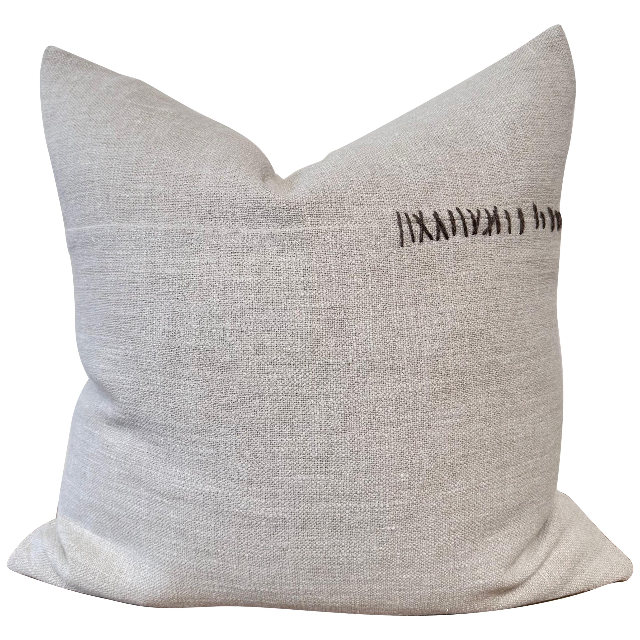Almohada de lino tejido con textura pesada y detalles de puntadas a mano