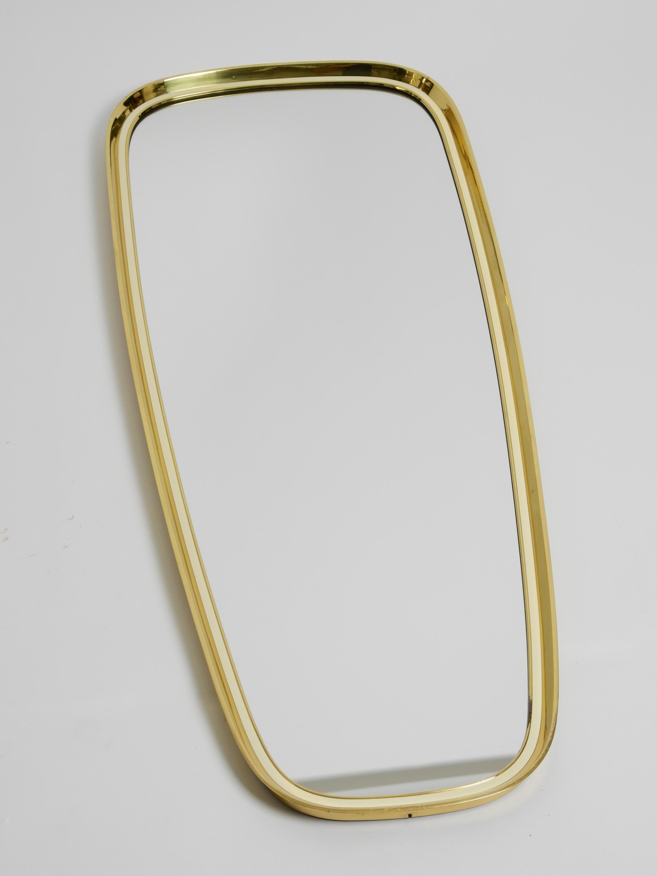 Extraordinary heavy large mid-century brass wall mirror by Münchner Zierspiegel, made in Germany.

Great 1950s minimalistic elegant design. Very high quality production. Heavy and very solidly built. An unusually thick, continuous brass frame, which