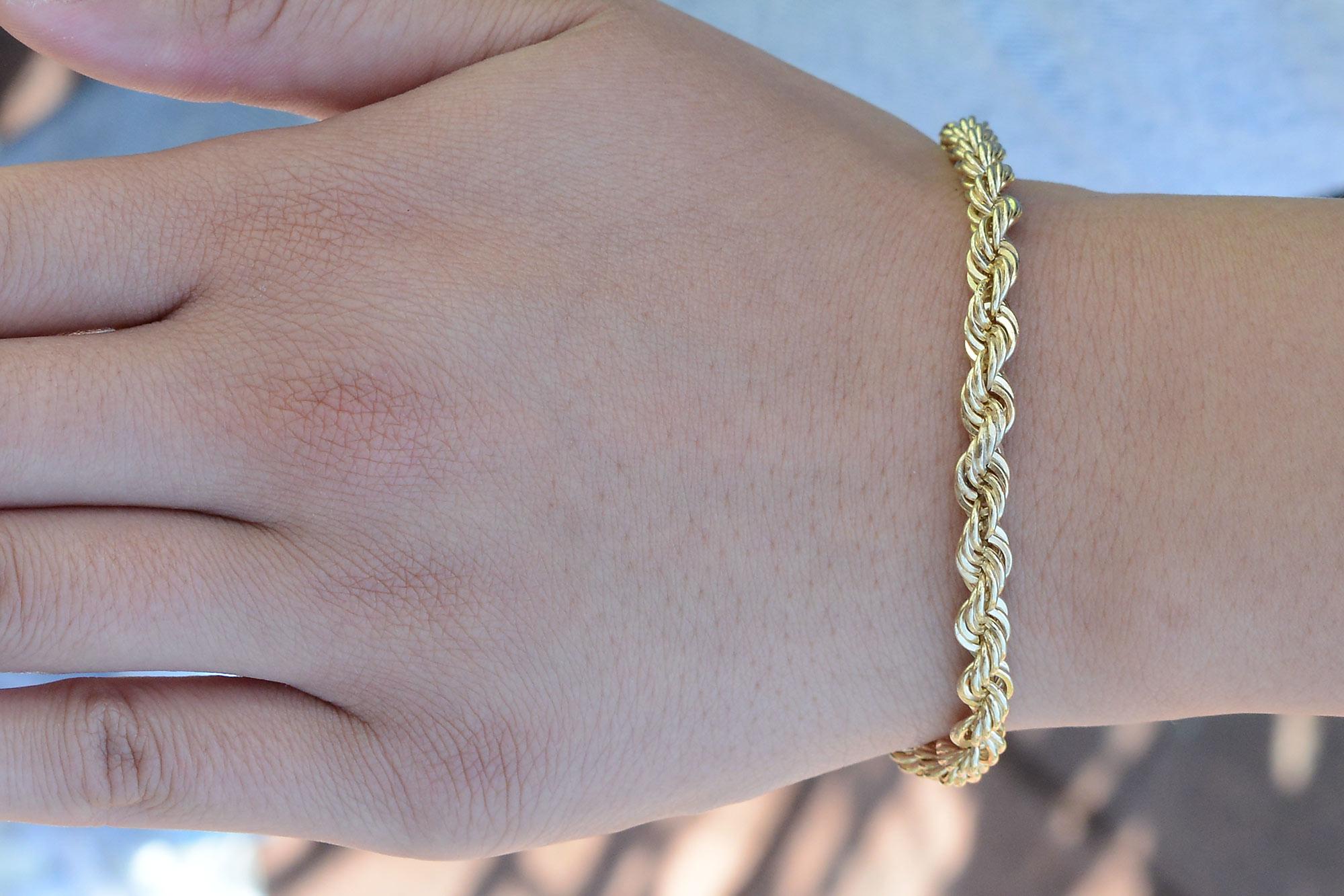 A vintage solid rope chain bracelet composed of rich 14k yellow gold. The twisting torsade of heavy gold wraps around your wrist elegantly and comfortably completed with a secure barrel clasp and safety chain. The substantial weight of 2/3 of an