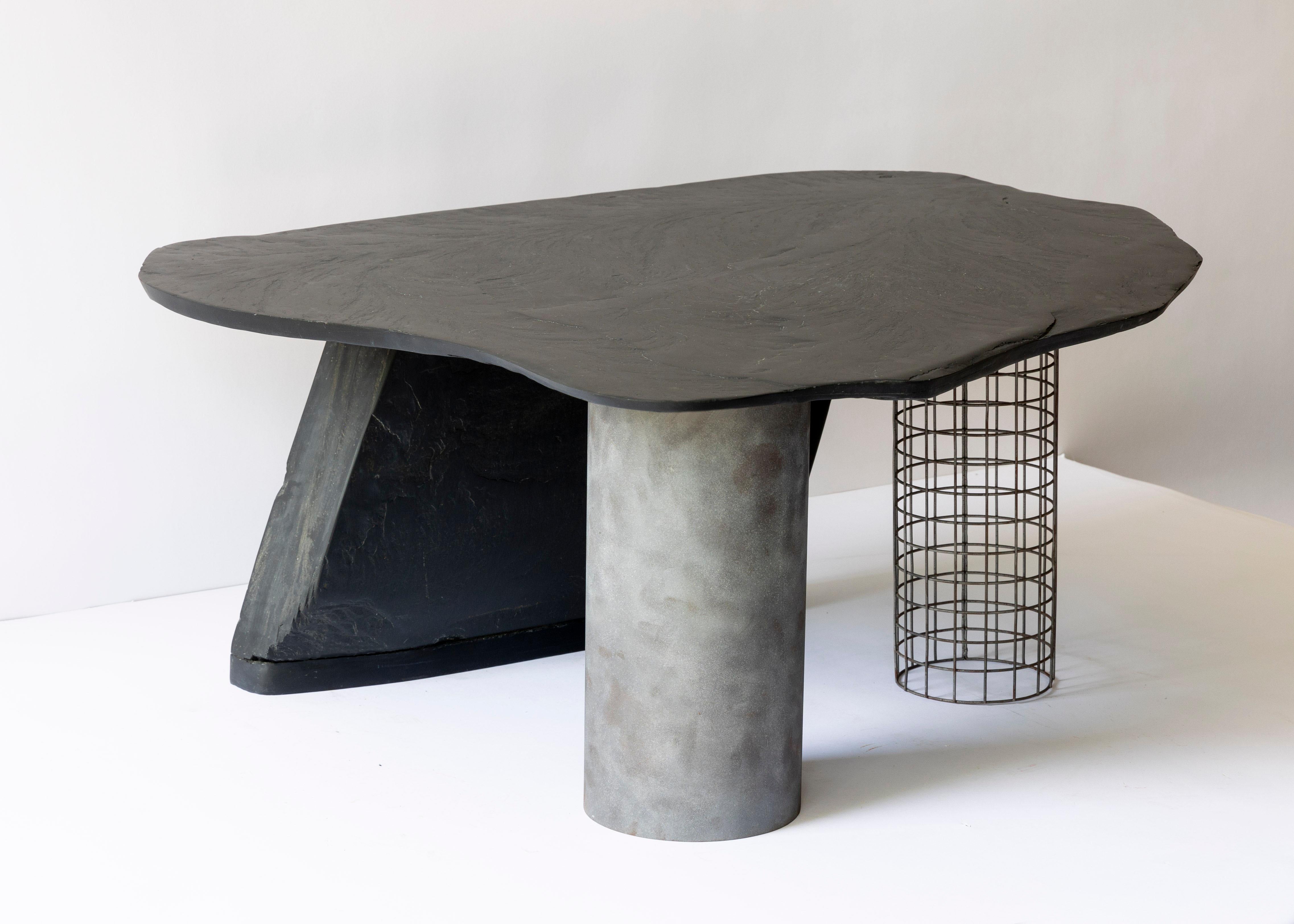 Table Heron par Lauren Goodman
Dimensions : 86,3 x 94 x 35,5 cm : P 86,3 x L 94 x H 35,5 cm. 
MATERIAL : Ardoise noire taillée, acier de récupération.
Chaque pièce est unique.

La table Hebron est fabriquée à partir d'ardoises glanées sur les rives