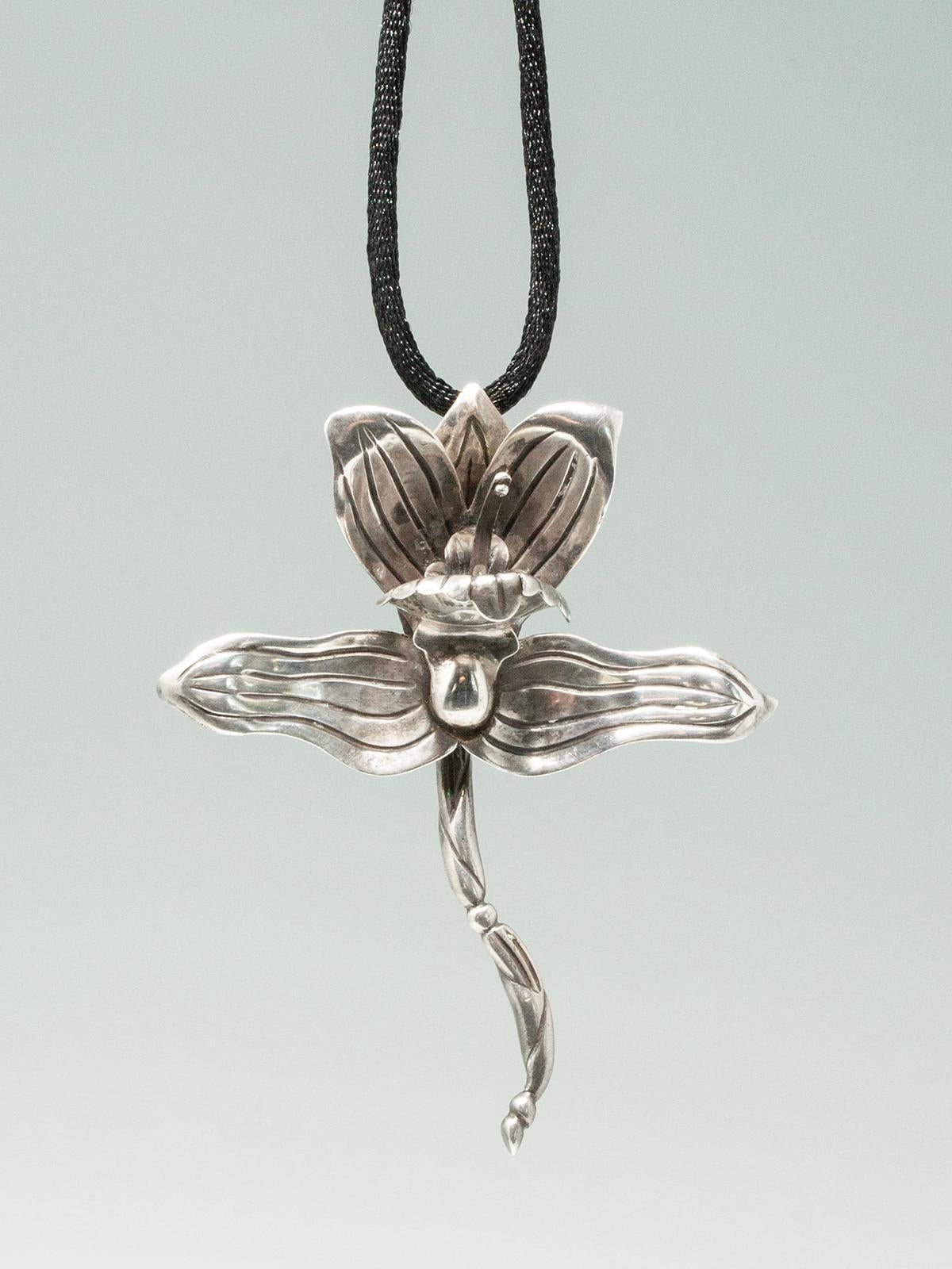 Beautiful and commanding sterling silver orchid pendant on a cord chain. Each part of the orchid is individually crafted. Clasp closure.  

Mexican silversmith artist Hector Aguilar began his career at age 30 working for William Spratling as his