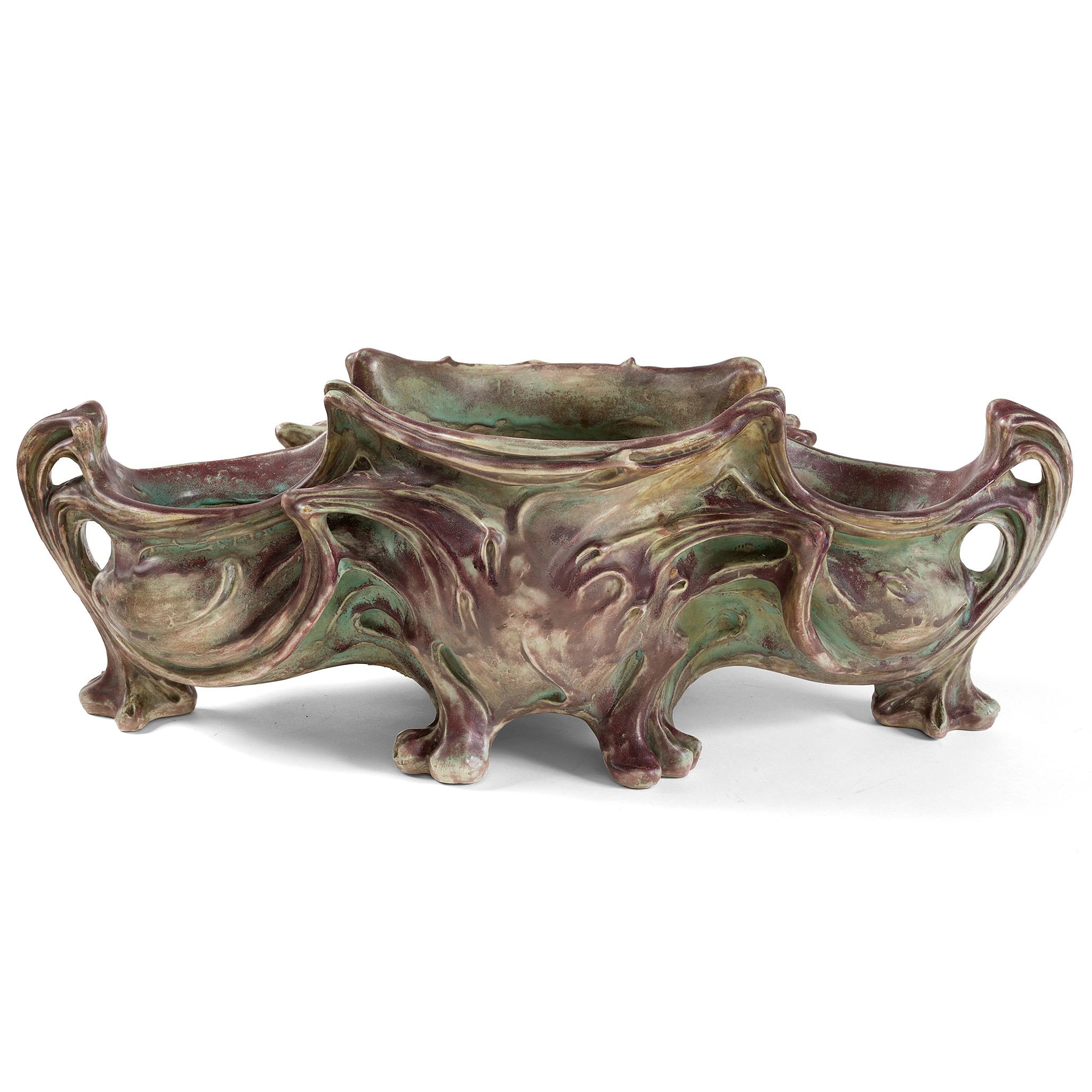 An ocean of sinuous, sweeping lines frozen in motion, this large-scale ceramic Art Nouveau planter by Hector Guimard (executed by Gilardoni et Brault, Choisy-le-Roi), demonstrates in an arresting array of earthen greenish and purplish hues, and is