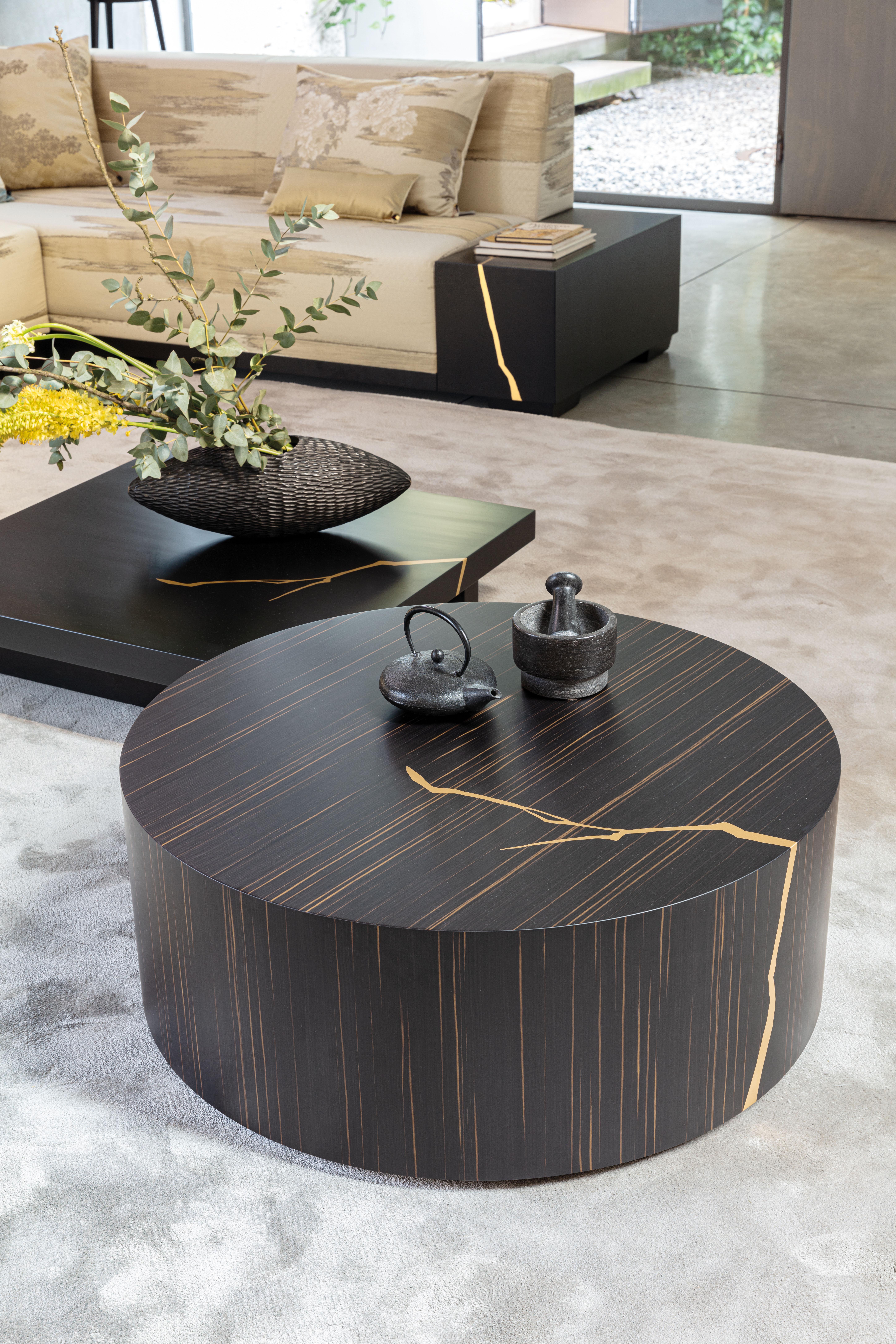 Bold and innovative in its design, this low side table has a unique and sophisticated character that enlivens modern living spaces. The sleek round shape is crafted from wood fibre and hand-finished with a dark Ammara ebony lacquer, enriched with a