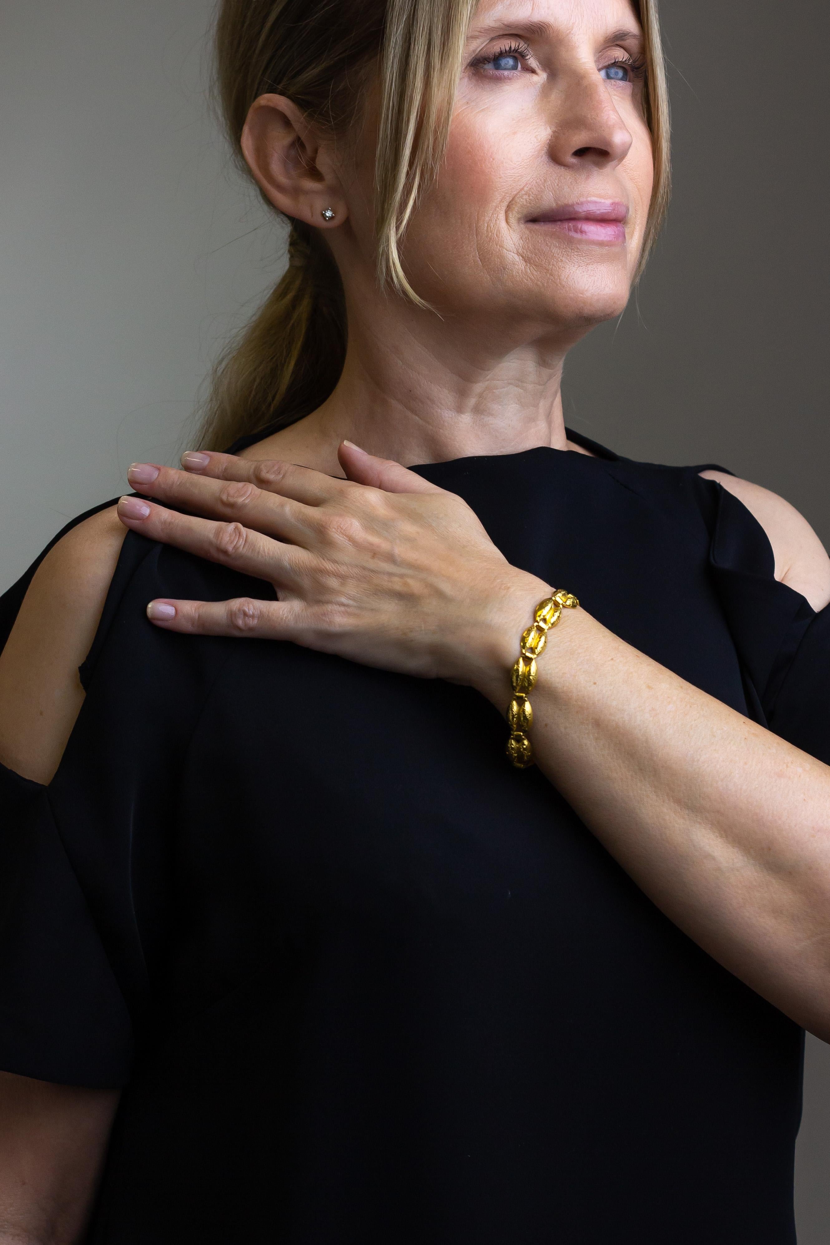 This wonderfully hefty yellow gold bracelet is crafted from solid 22 karat yellow gold. The fancy links are double marquise shaped domed links that have been engraved with a delicate motif. The marquise shaped links are joined by 'tube' shaped links