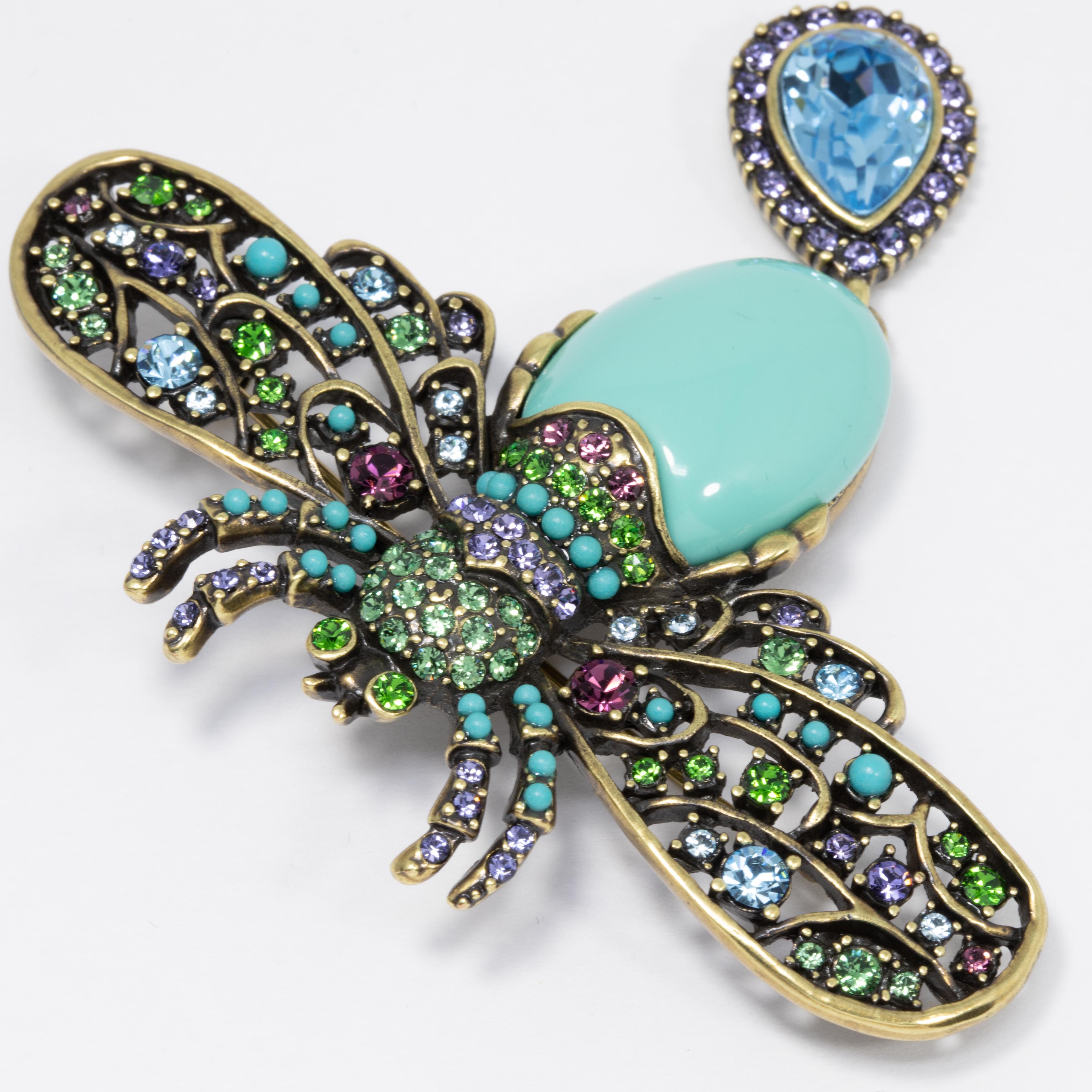 Make a buzz with this fabulous pin by Heidi Daus! This bee is decorated with amethyst, peridot, rose, and aquamarine crystals and a turquoise cabochon abdomen. A aquamarine tear-shaped crystal dangles off the bottom, accented with amethyst