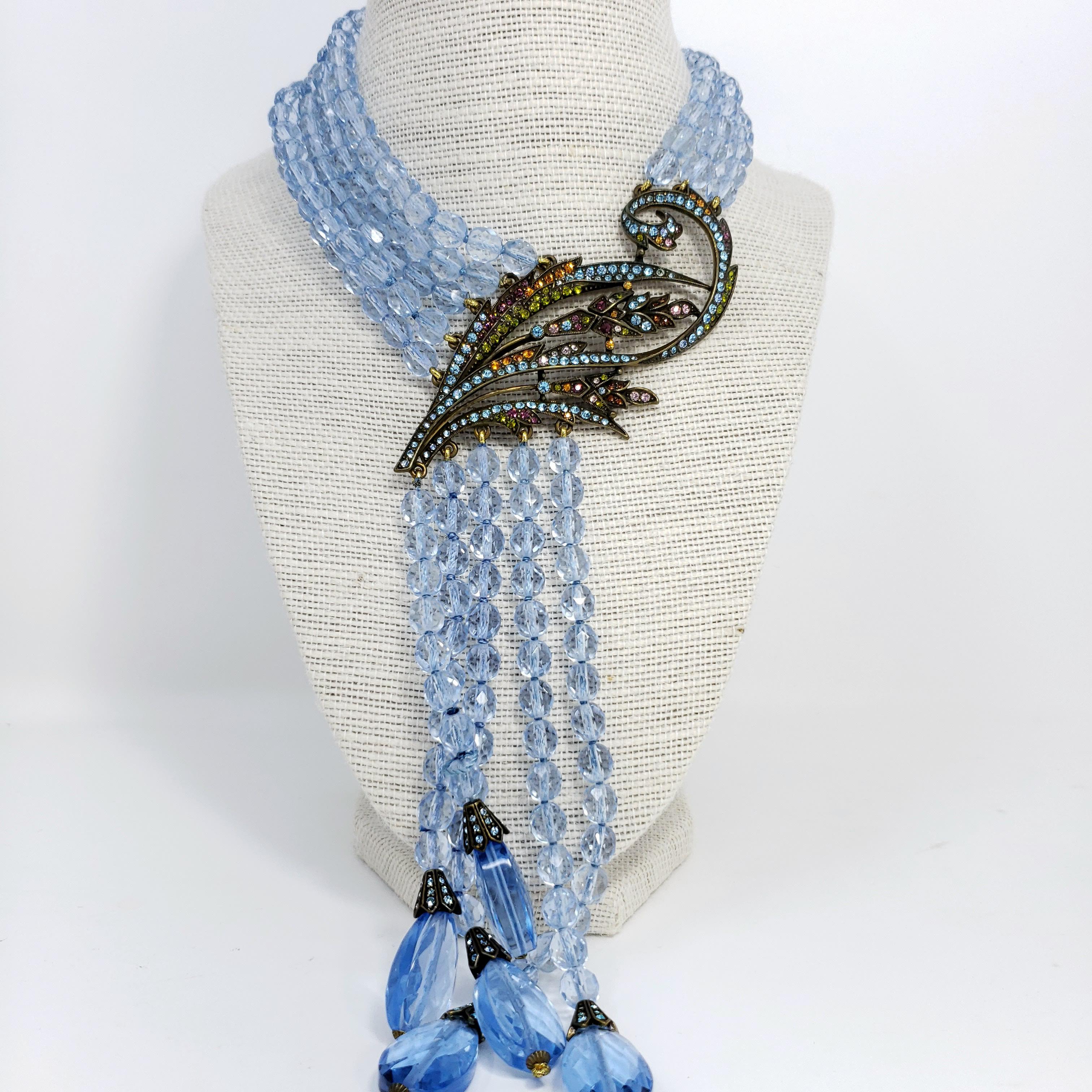 A waterfall of aquamarine crystals! This elegant multi-strand drop necklace features translucent, faceted aquamarine crystals with a floral-themed crystal-encrusted centerpiece. A stylish accessory by Heidi Daus.

Length: 36 cm + 9 cm extension