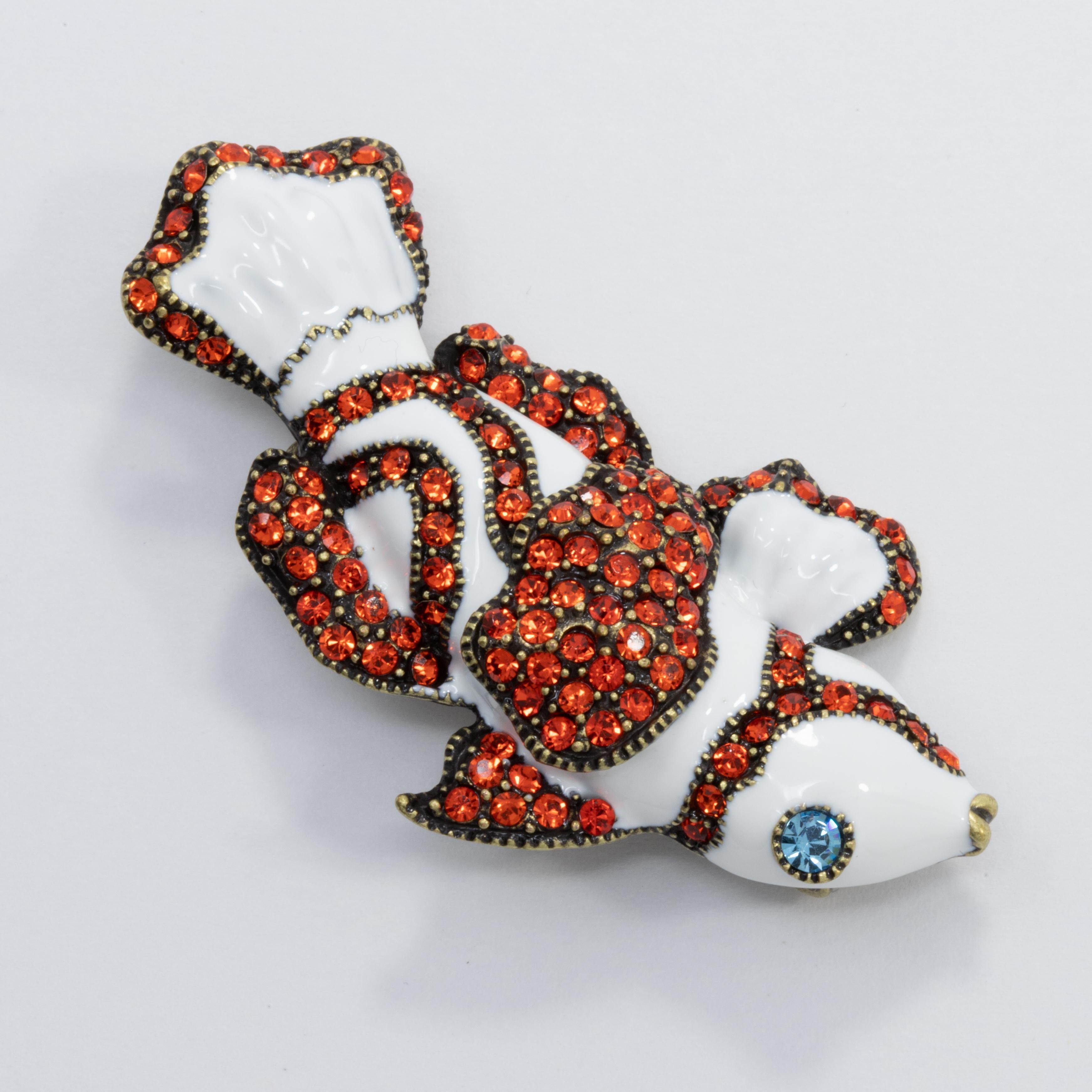 Glamorous ocean-themed pin brooch from Heidi Daus. An exotic clownfish, decorated with tangerine crystals and white enamel.

Brass tone.

Marks / hallmarks: Heidi Daus, CN