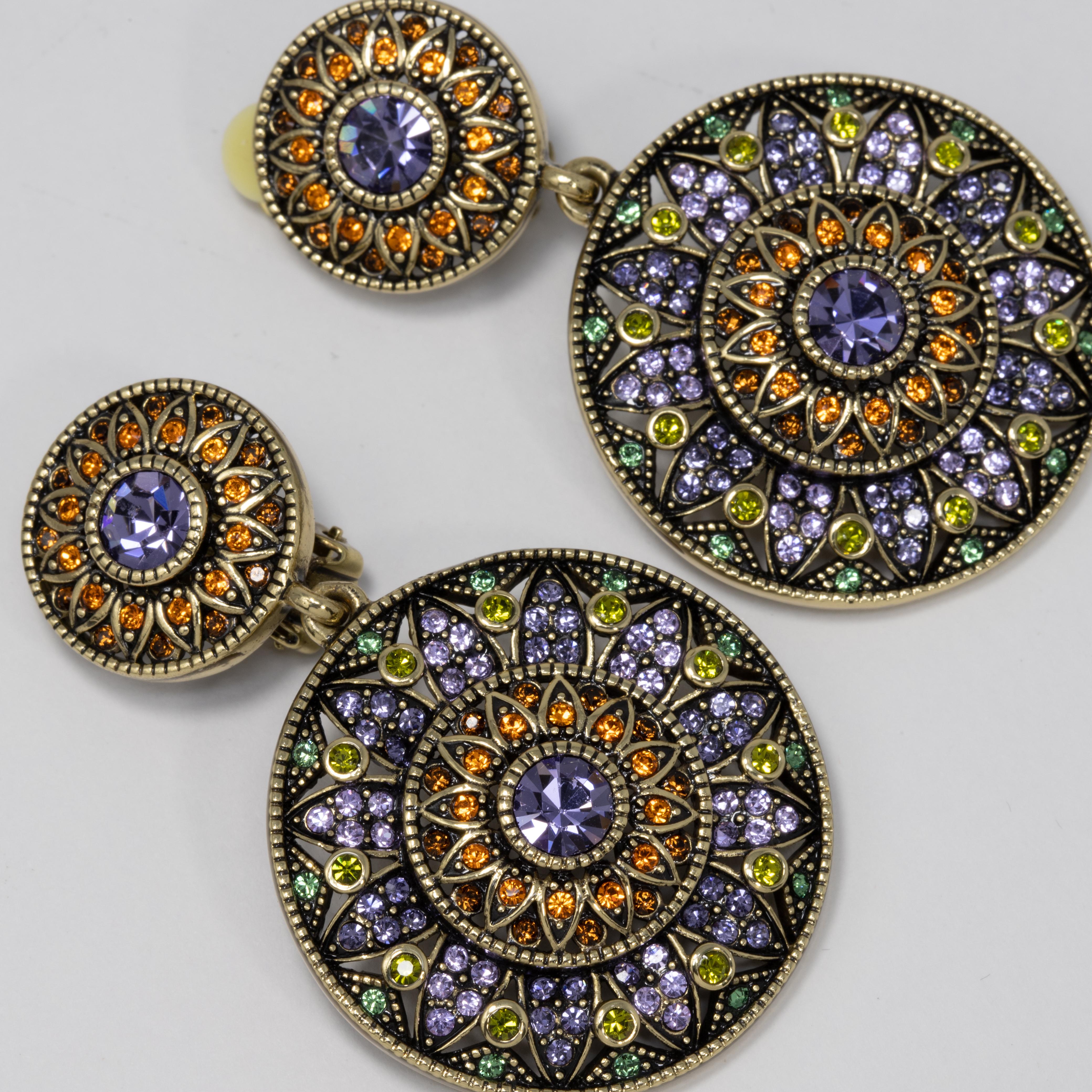 Heidi Daus ornate dangling clip on earrings. Feature two circular dangling flower motifs decorated with amethyst, citrine, and olive crystals.

Hallmarks: Heidi Daus, China

