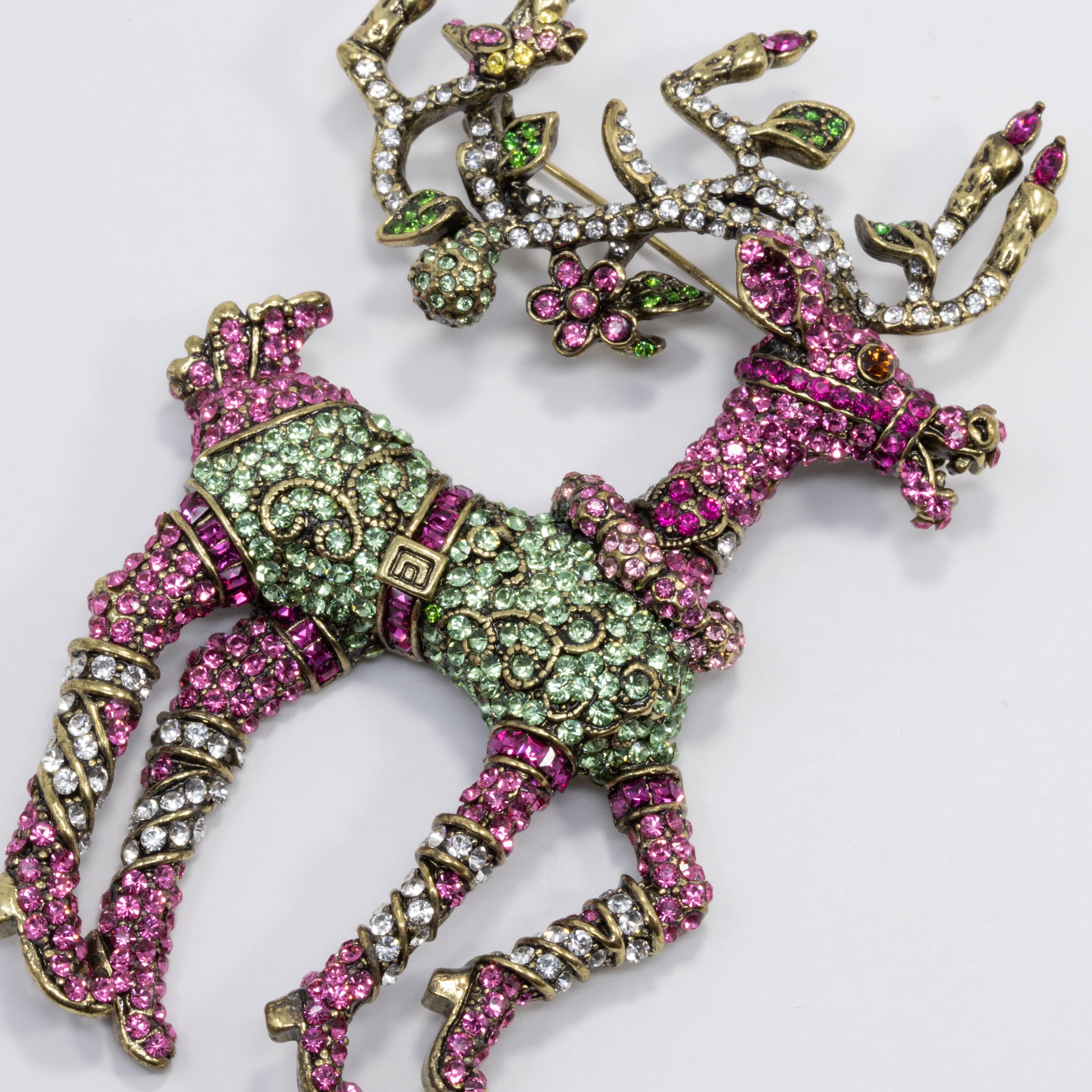 A whimsical pin by Heidi Daus. This lovely brooch features a reindeer, decorated with colorful pave crystals in purple, pink, and green. Set on matching brass tone metal.

Hallmarks: Heidi Daus