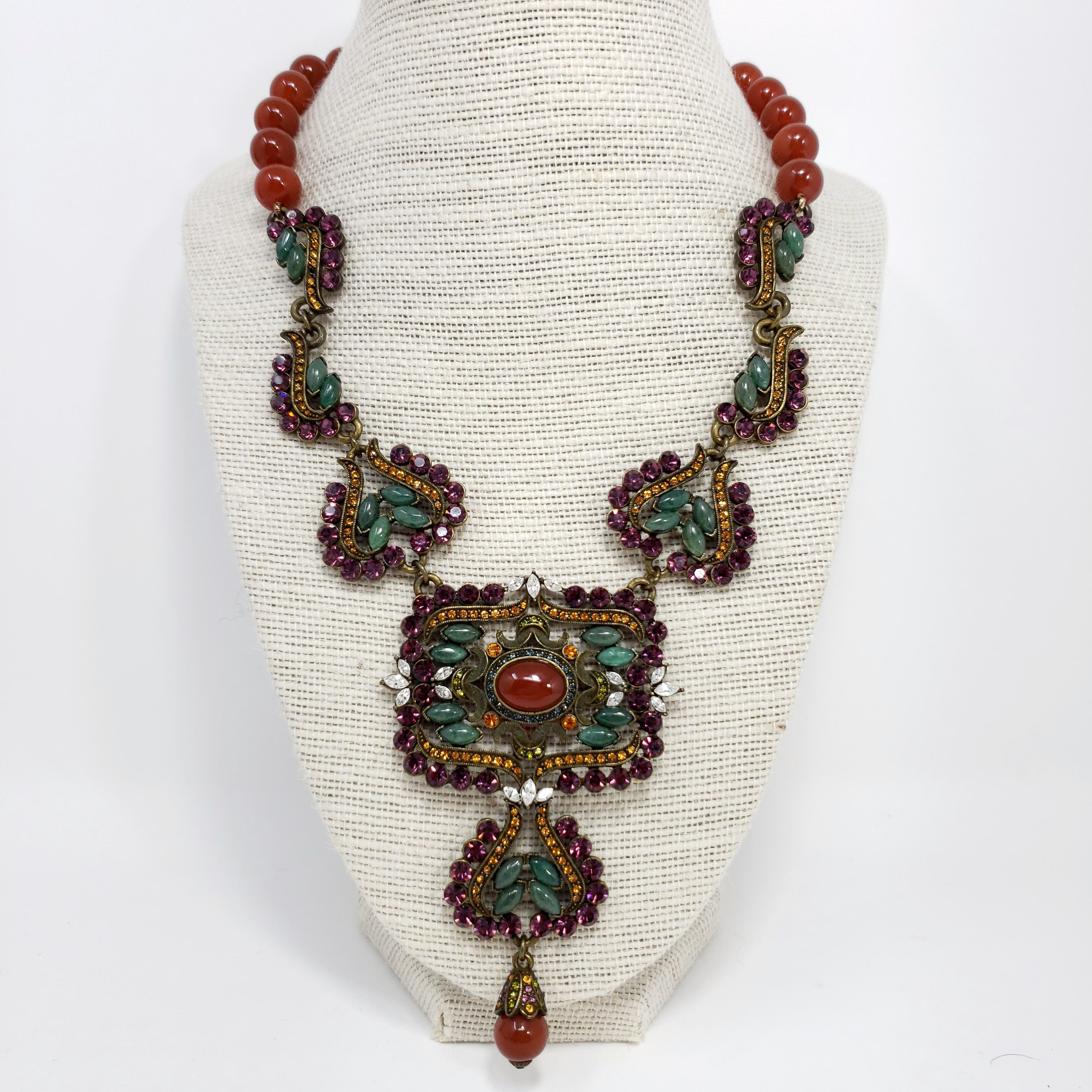 A showstopping necklace from Heidi Daus. This bold pendant necklace features amethyst, jade, & citrine crystals, and natural carnelian beads for a stylish, exotic, look.

Brass tone.

Marks / hallmarks: Heidi Daus, CN

Length: 15 to 18 inches (with