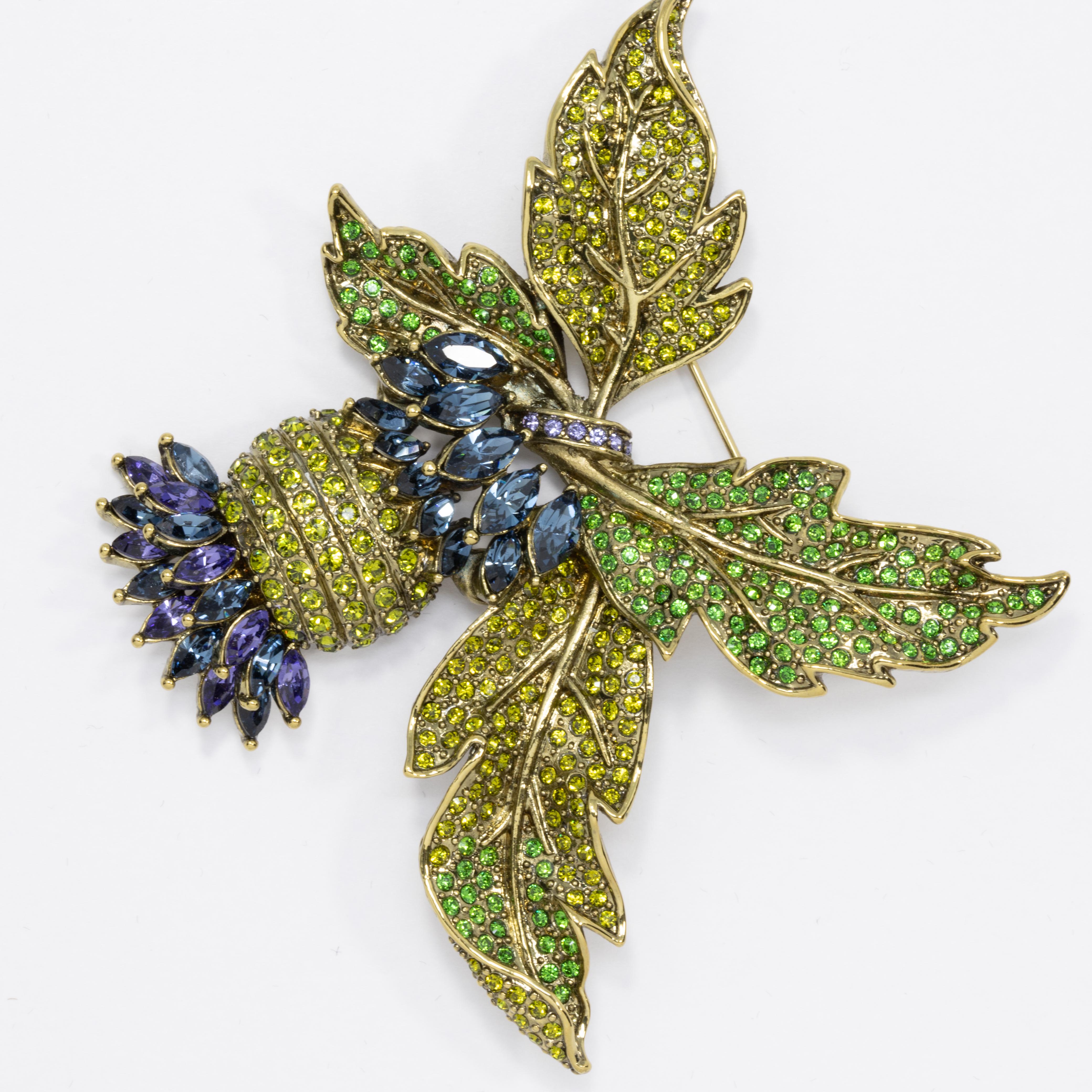 A sparkling pin brooch from Heidi Daus! An extravagant cluster of leaves and fruit, decorated with pave olive, peridot, and violet crystals.

Limited-time, retired collection.

Hallmarks: Heidi Daus, CN