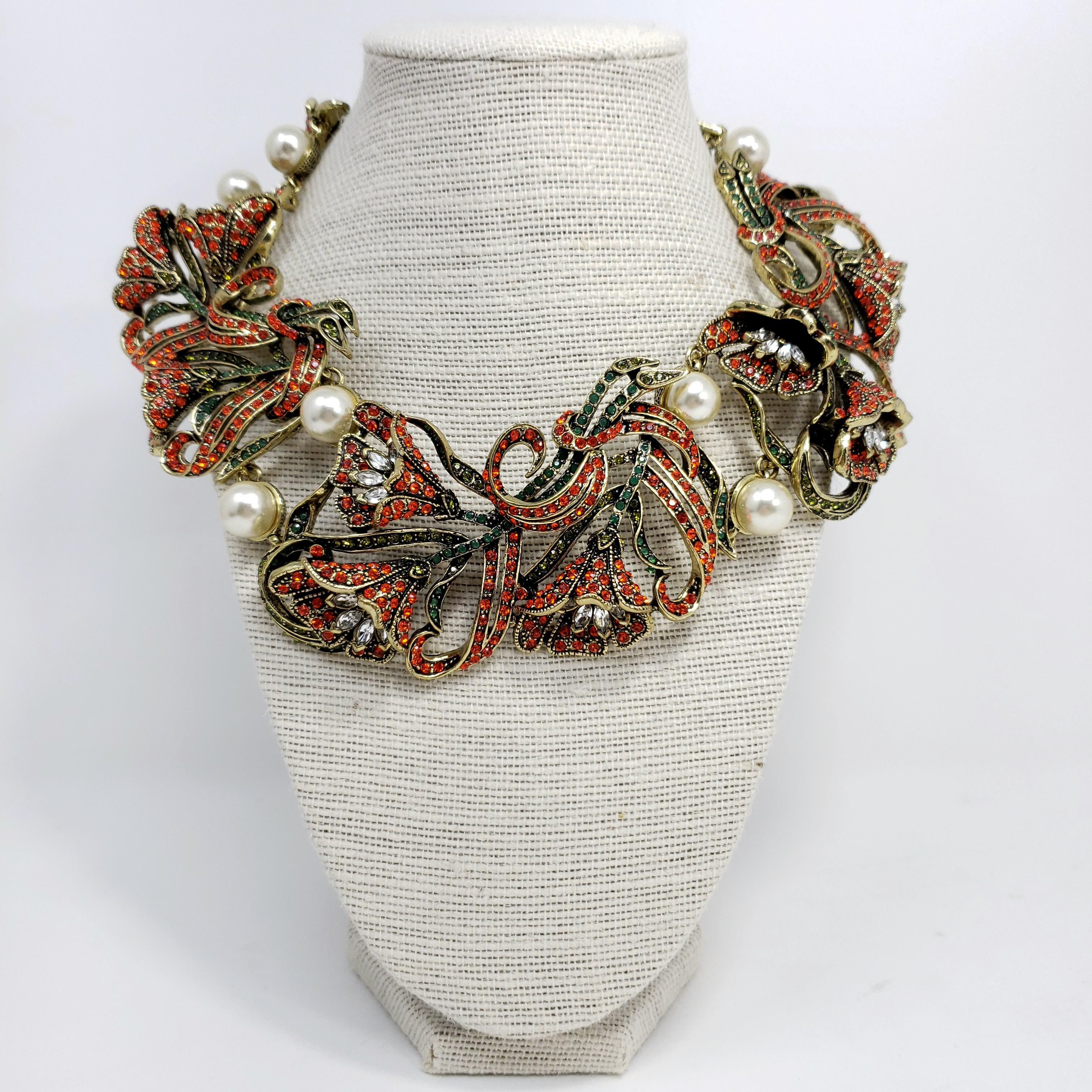 Let your jewelry wardrobe blossom with this jeweled Heidi Daus necklace. Links of extravagant, crystal-encrusted tulips decorated with pairs of faux pearls in between.

Clear, emerald, and fireopal crystals.

Length: 40 cm / 15.5 in around, plus 9