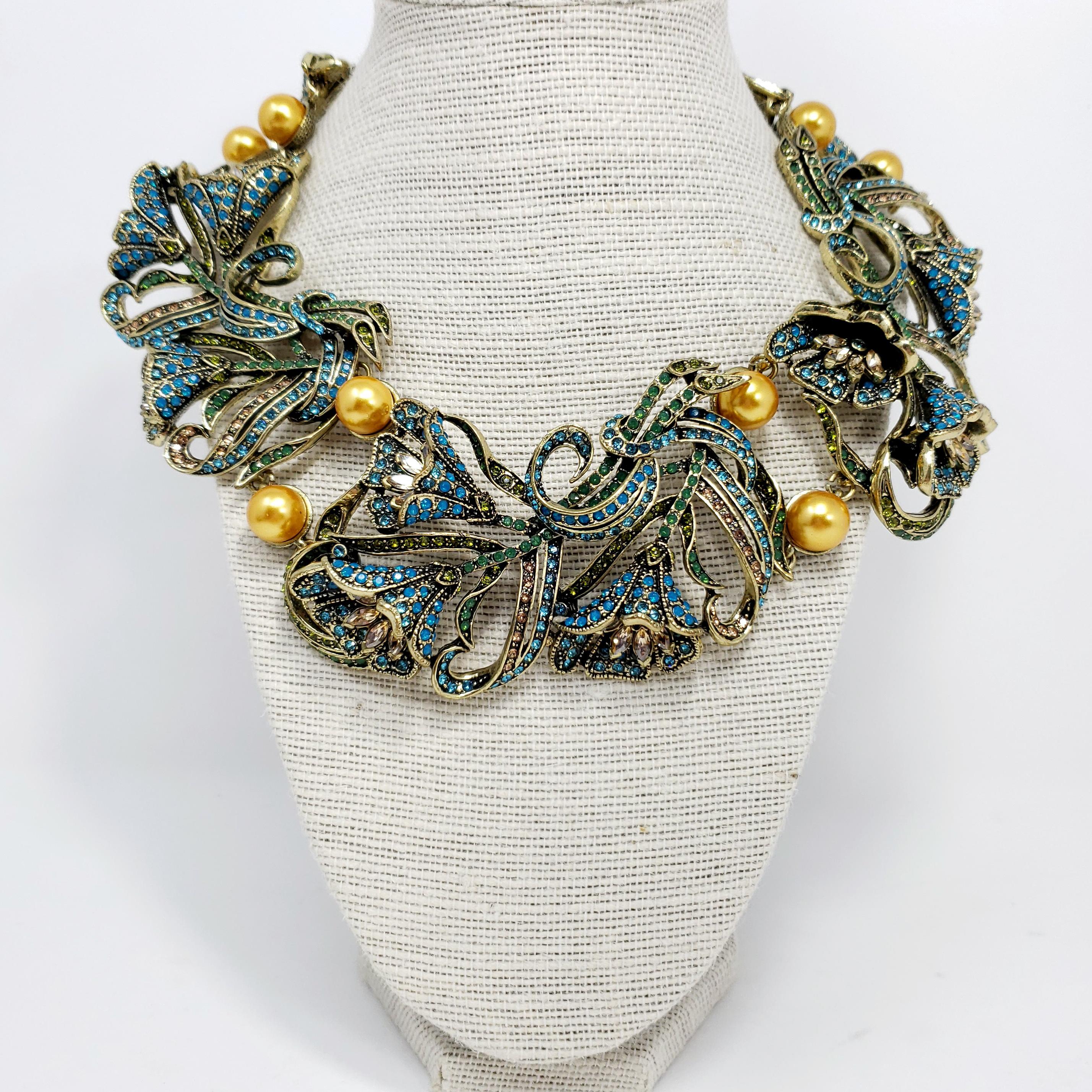 Let your jewelry wardrobe blossom with this jeweled Heidi Daus necklace. Links of extravagant, crystal-encrusted tulips decorated with pairs of faux pearls in between.

Clear, olivine, and turquoise crystals.

Length: 40 cm / 15.5 in around, plus 9