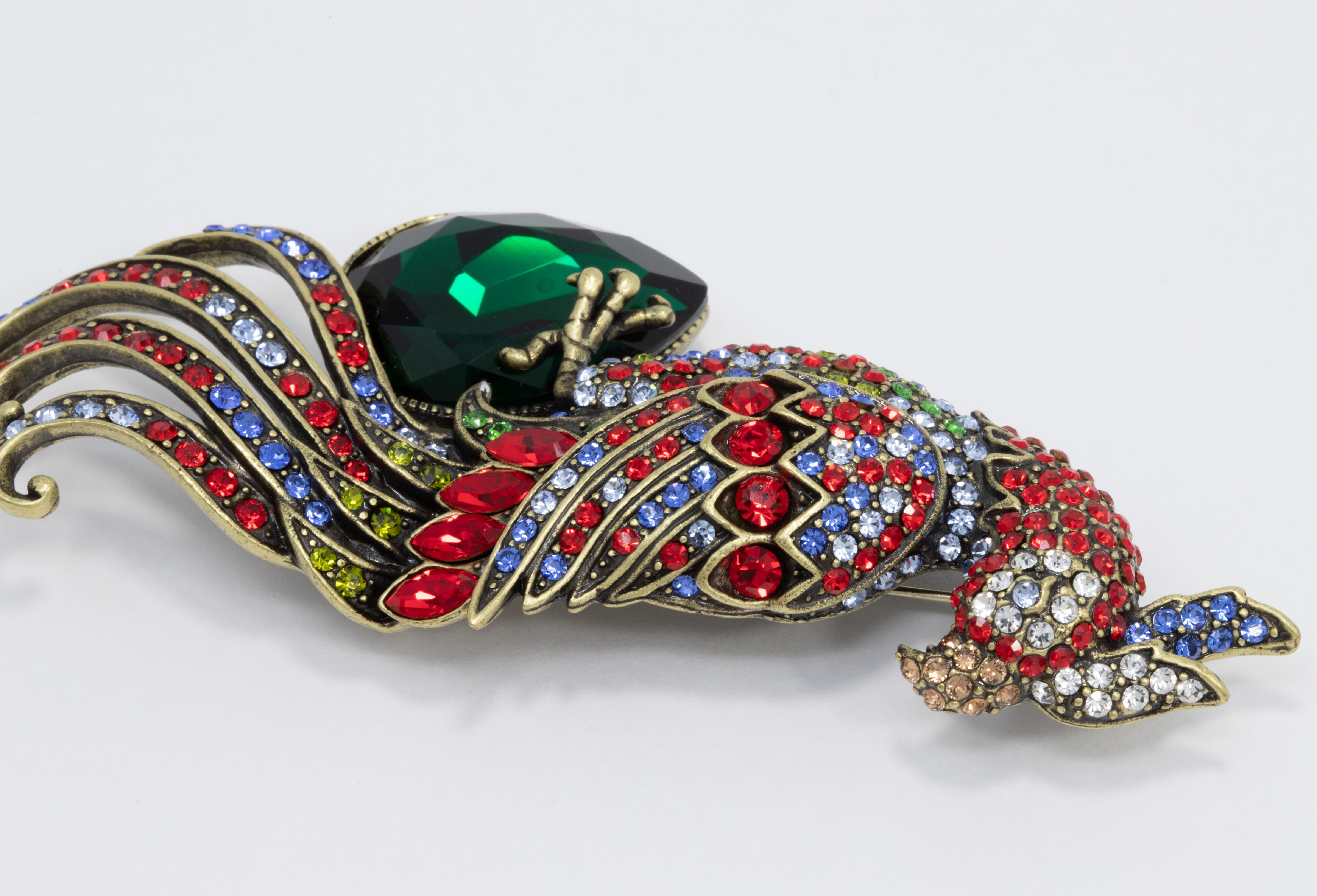 A pretty perched bird by Heidi Daus! This vibrant pin brooch is the perfect touch of lively glamour. Decorated with pave ruby, aquamarine, and emerald crystals. 

Marks / hallmarks / etc: Heidi Daus, CN