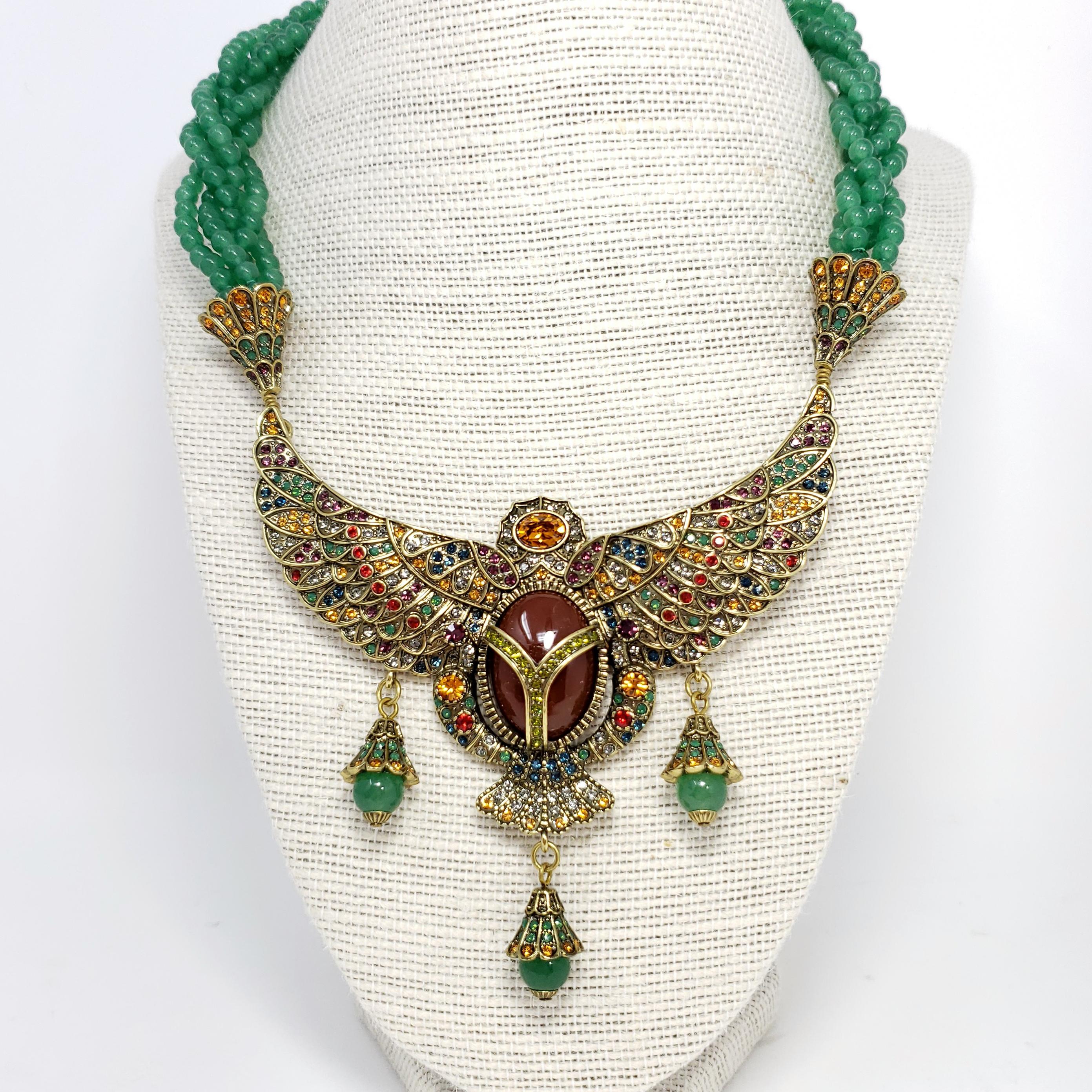 Inspired by the most important amulet in ancient Egyptian history, this sacred winged scarab design symbolizes rebirth and renewal. Five twisted strands of simulated aventurine beads lead to a bold, winged Egyptian scarab-designed drop. Large, oval