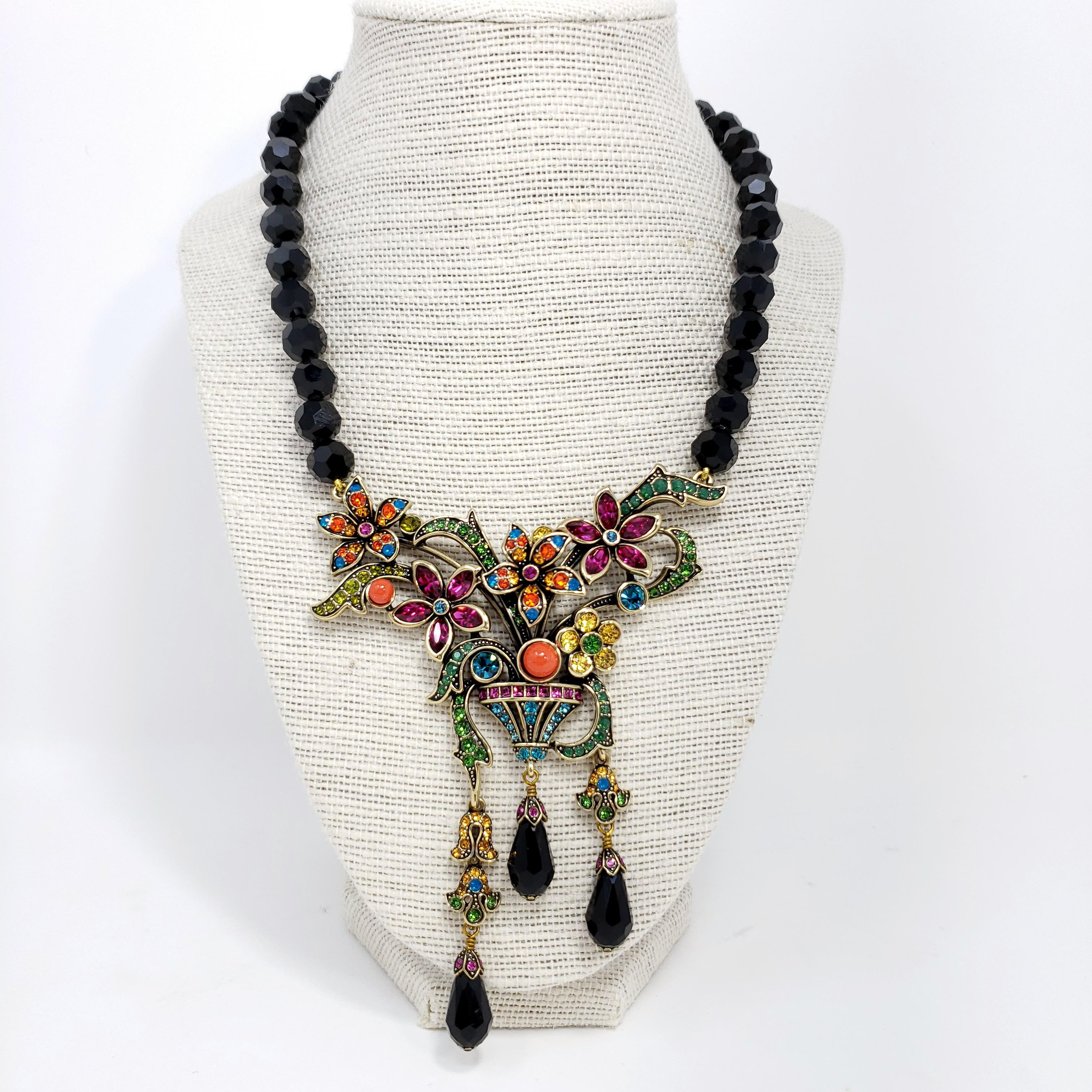 A garden of glamour! This colorful statement necklace is a wearable floral bouquet. A single strand of individually knotted faceted jet beads leads to a stunning floral designed center station drop with fancy cut bezel and pave set Swarovski