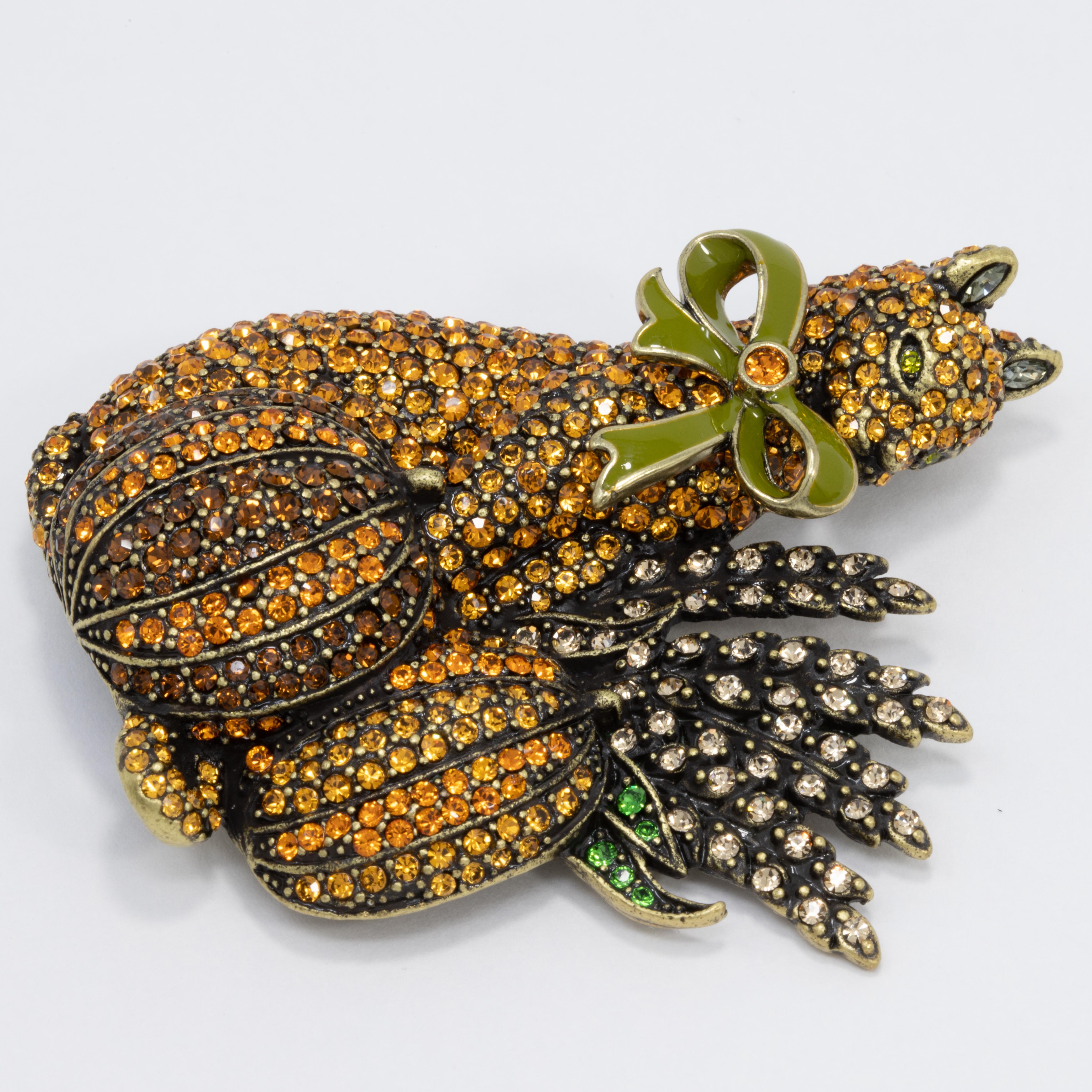 An adorable cat set between two shining pumpkins and glamorous wheat stalks. Decorated with pave glimmering crystals, this piece is finished off with a lovely enamel bow collar. Add a bit of feline fancy to your ensemble today!

By Heidi