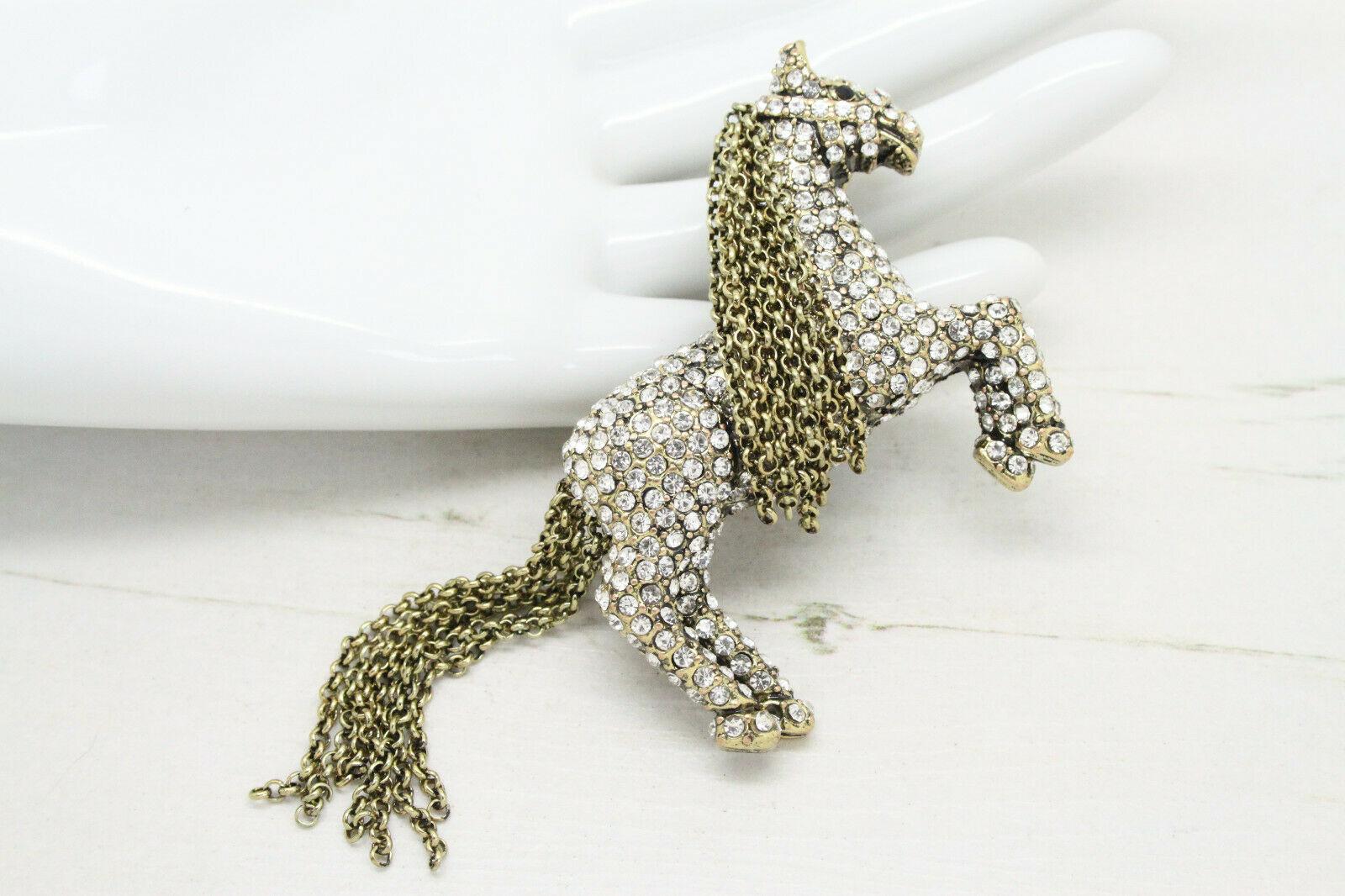 Chic and Dramatic, highly detailed Signed HEIDI DAUS Pony Tally Ho Horse design brooch encrusted with pave-set sparkling Crystals. Mane and Tail composed of multi strands of free falling chain. Antique gold tone setting. Measuring approx. 2.6