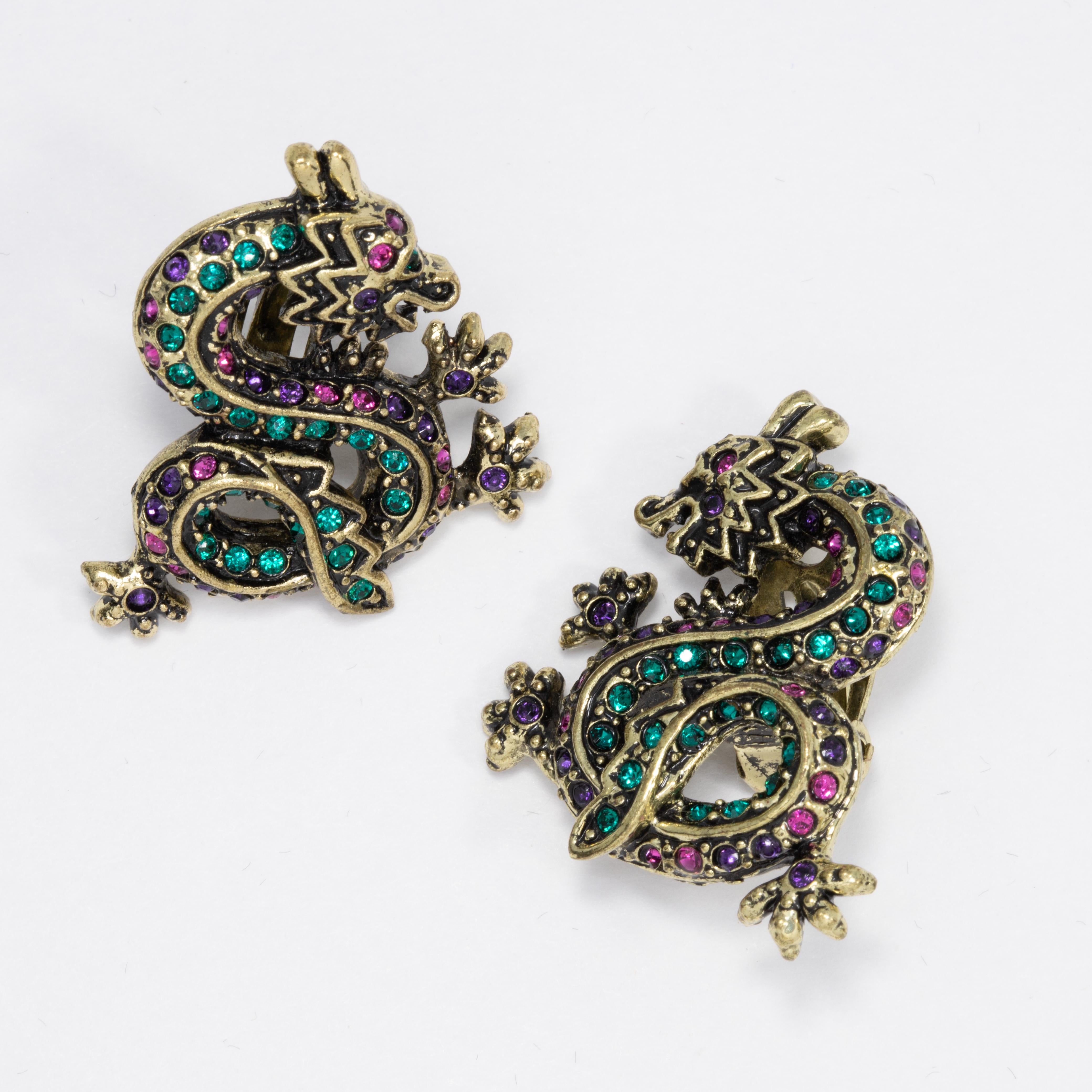 Crystal encrusted dragon clip on earrings from Heidi Daus. Each dragon features emerald, amethyst, and sapphire crystals set on antique brass-tone metal. 

Limited-time retired edition.

Hallmarks: Heidi Daus, CN