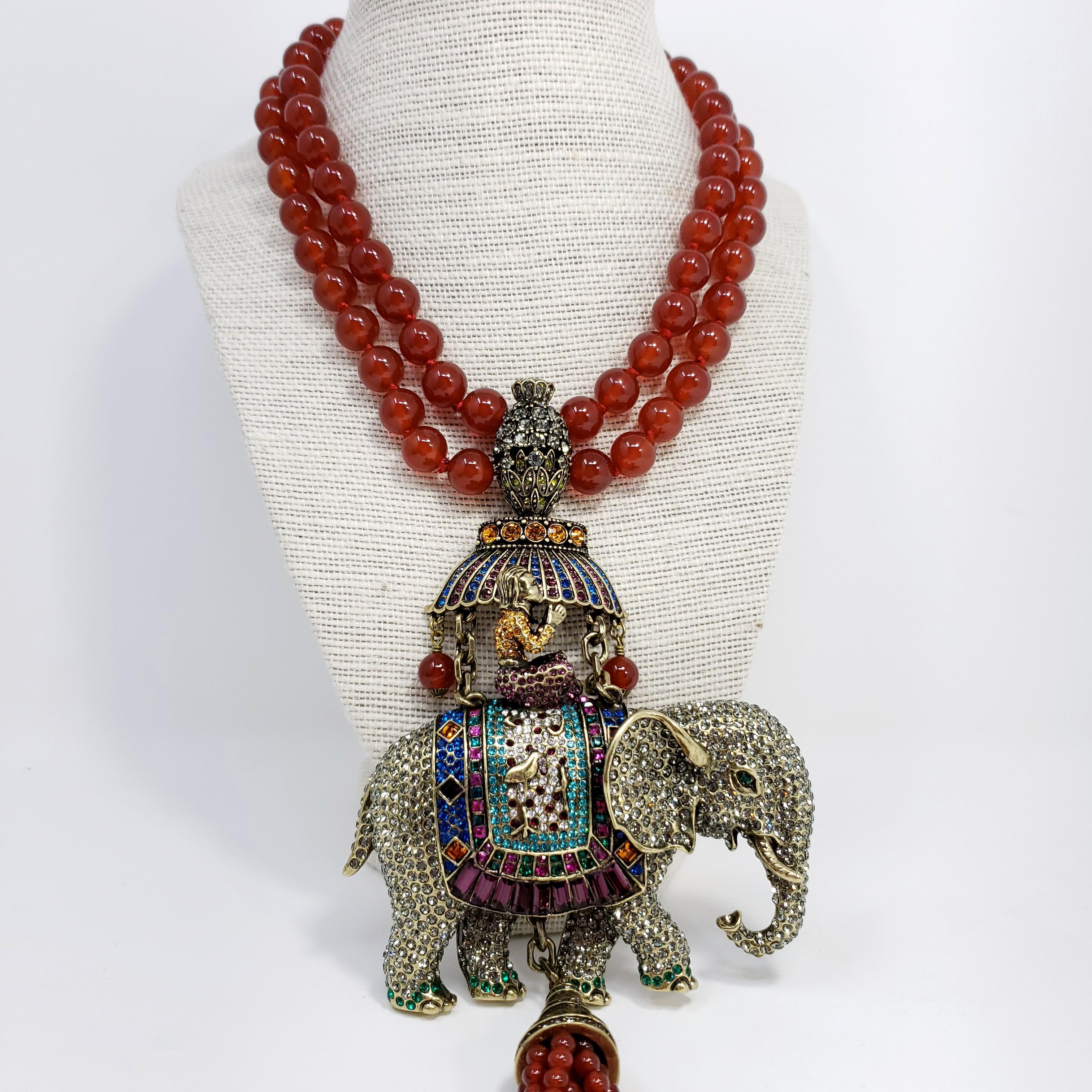 Exotic glamour from distant lands! This double-strand carnelian necklace features a dazzling elephant pendant and a carnelian & jade bead tassel. 

The elephant and rider are decorated with exquisite detail using clear, black diamond-, topaz-,