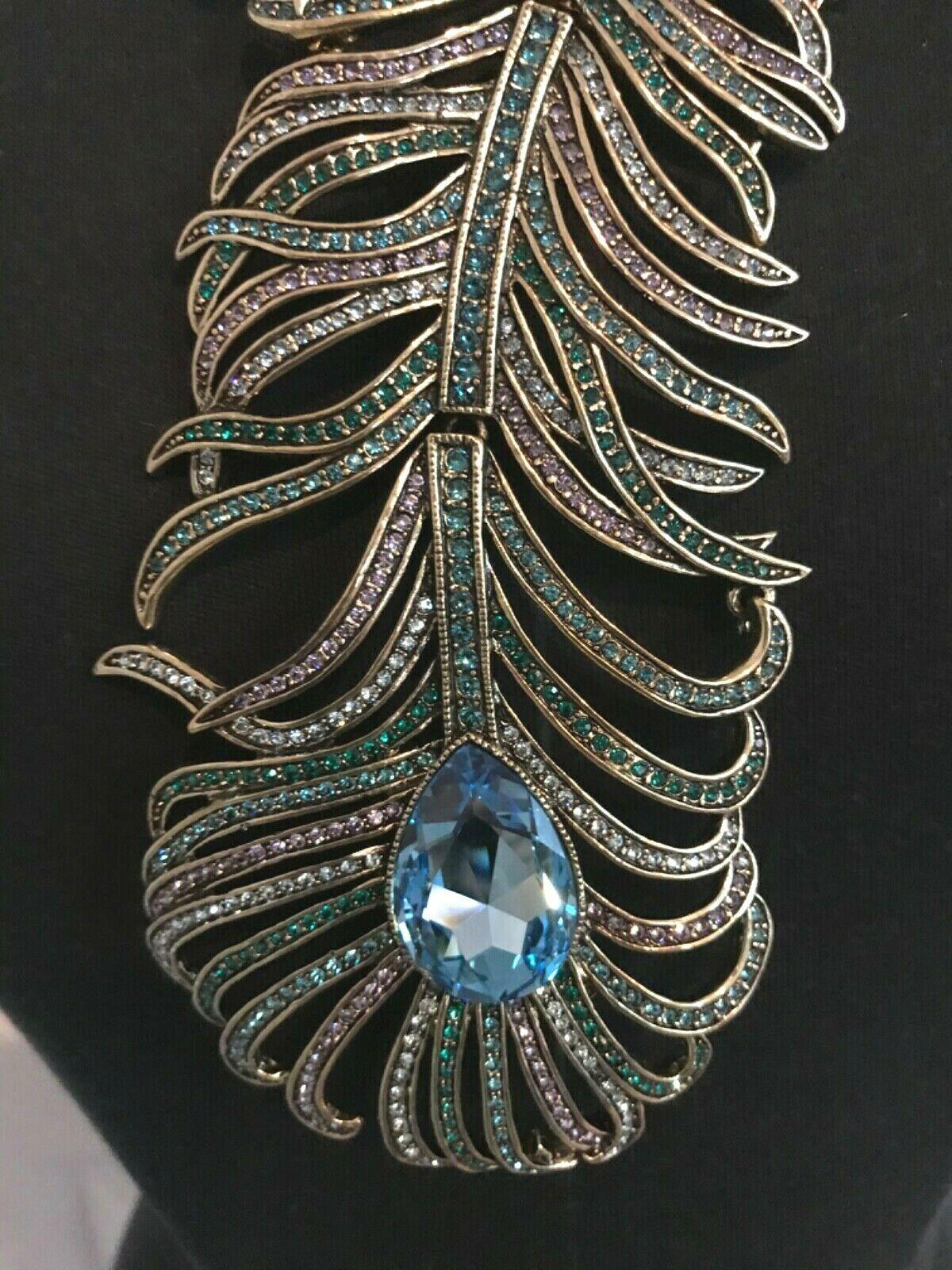 Outstanding Heidi Daus Swarovski crystal Peacock design Necklace. A single row of individually knotted Aurora Borealis Cushion cut faceted beads leads to a magnificent peacock feather designed asymmetrical station. The feather showcases a bezel set