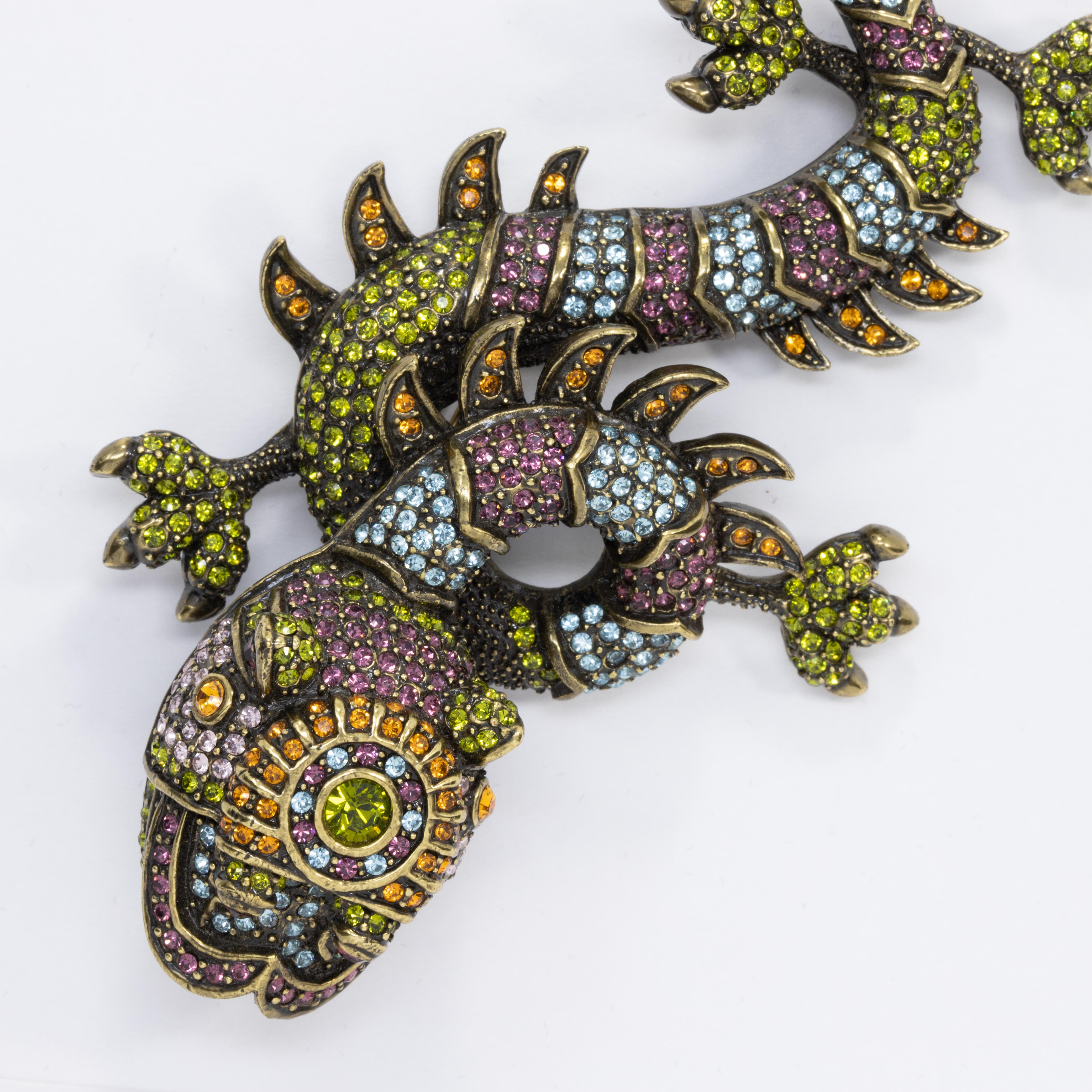 Stylish pin brooch by Heidi Daus! An exotic fu dog, decorated with colorful pave crystals. 

Citrine, olivine, amethyst, and aquamarine crystals.

Hallmarks: Heidi Daus, CN